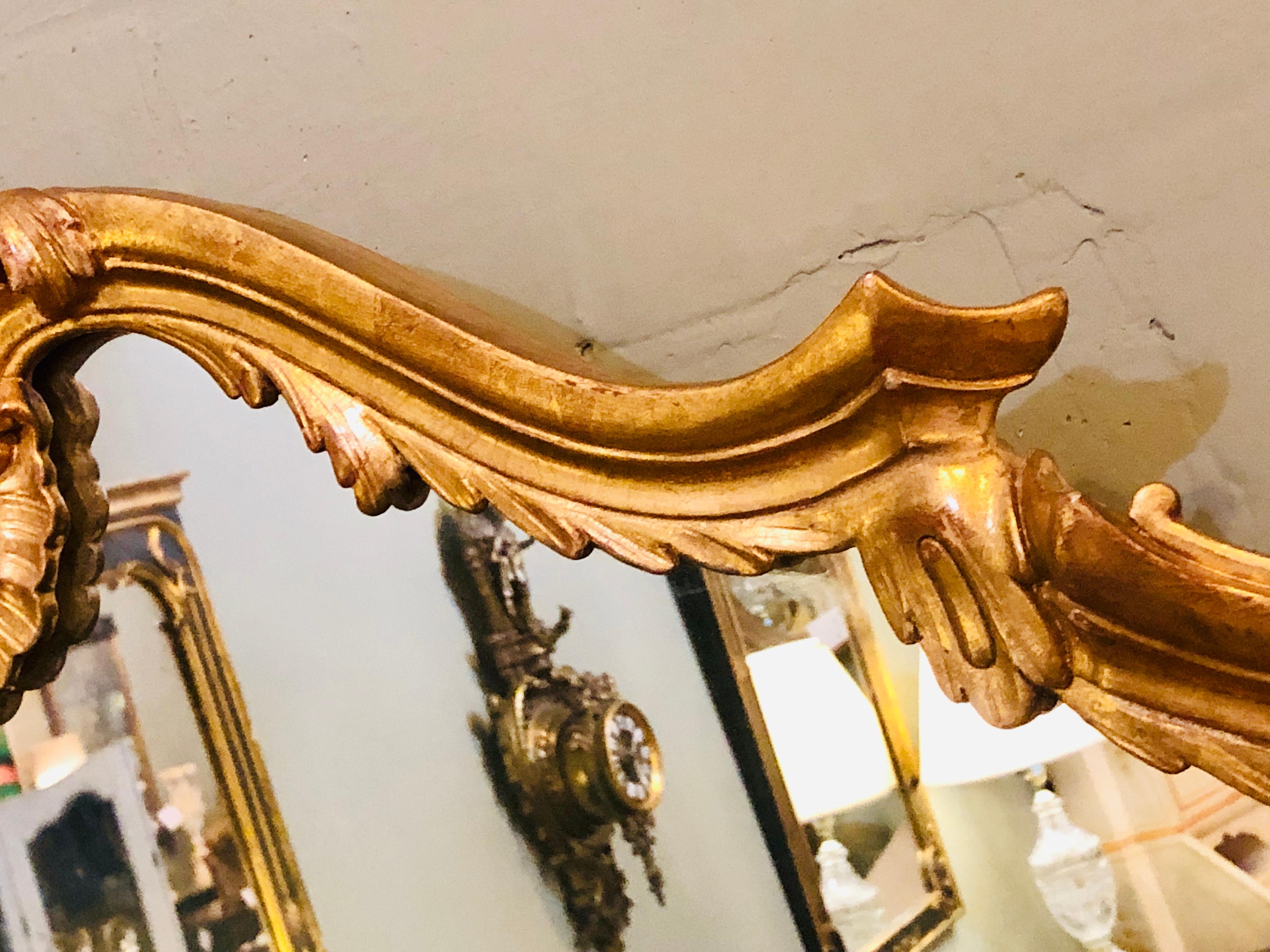 A large over the mantel sideboard or console mirror in a carved giltwood frame. This simply stunning mirror is certain to add the right reflection to any home or office.