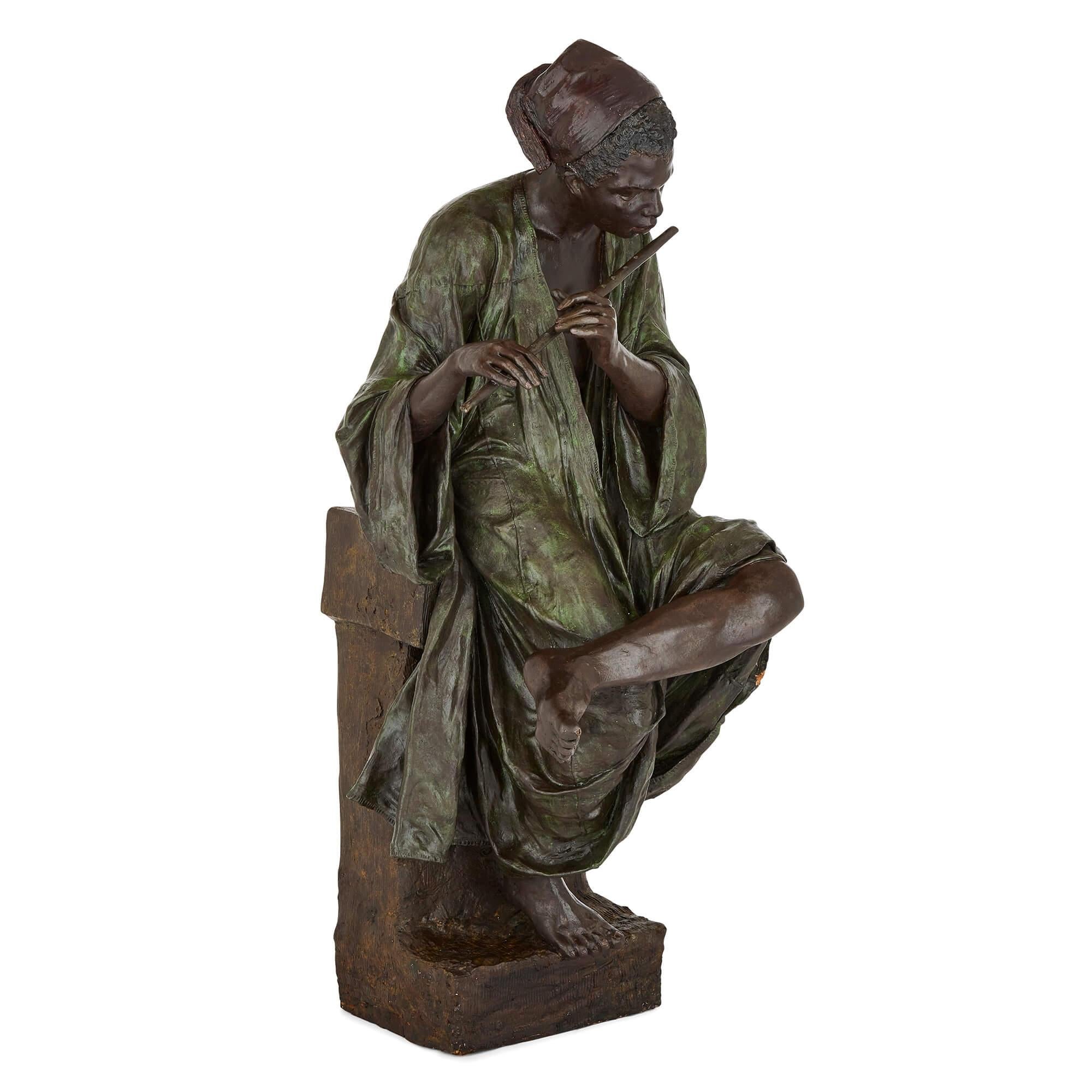 A large painted terracotta figure of a boy playing the flute by Goldscheider.
Austrian, c.1895
Measures: Height 115 cm, width 42 cm, depth 53 cm.

Marked 'Goldscheider / Reproduction Reservee,' this fine terracotta sculpture dates from around