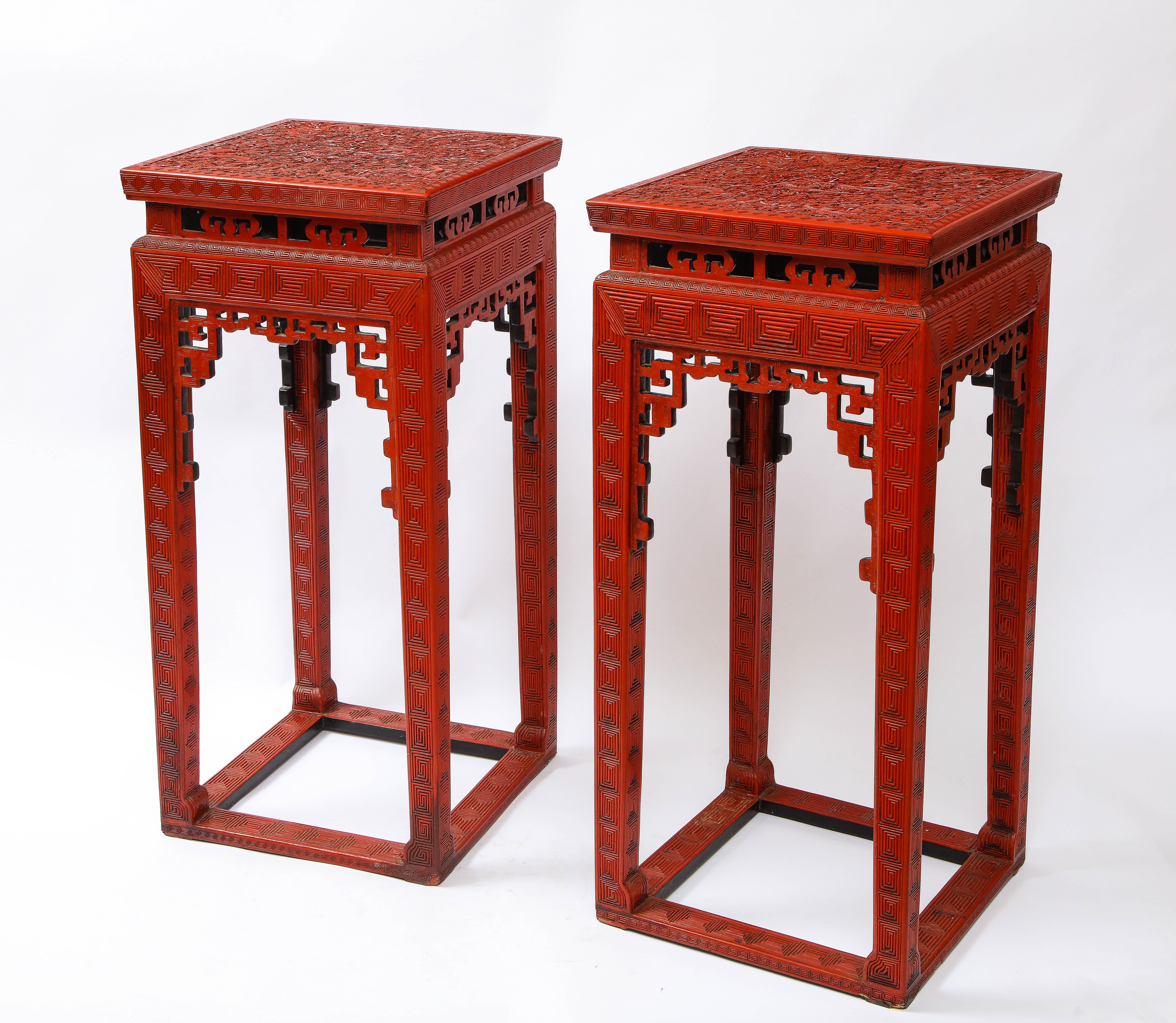 A Large Fabulous Pair of 19th Century Chinese Red Cinnabar Lacquer Five-Claw Dragon Pedestals.  Each pedestal rests on four long red legs, hand-carved with intricate maze-like square lines.  The square form top is beautifully decorated with five