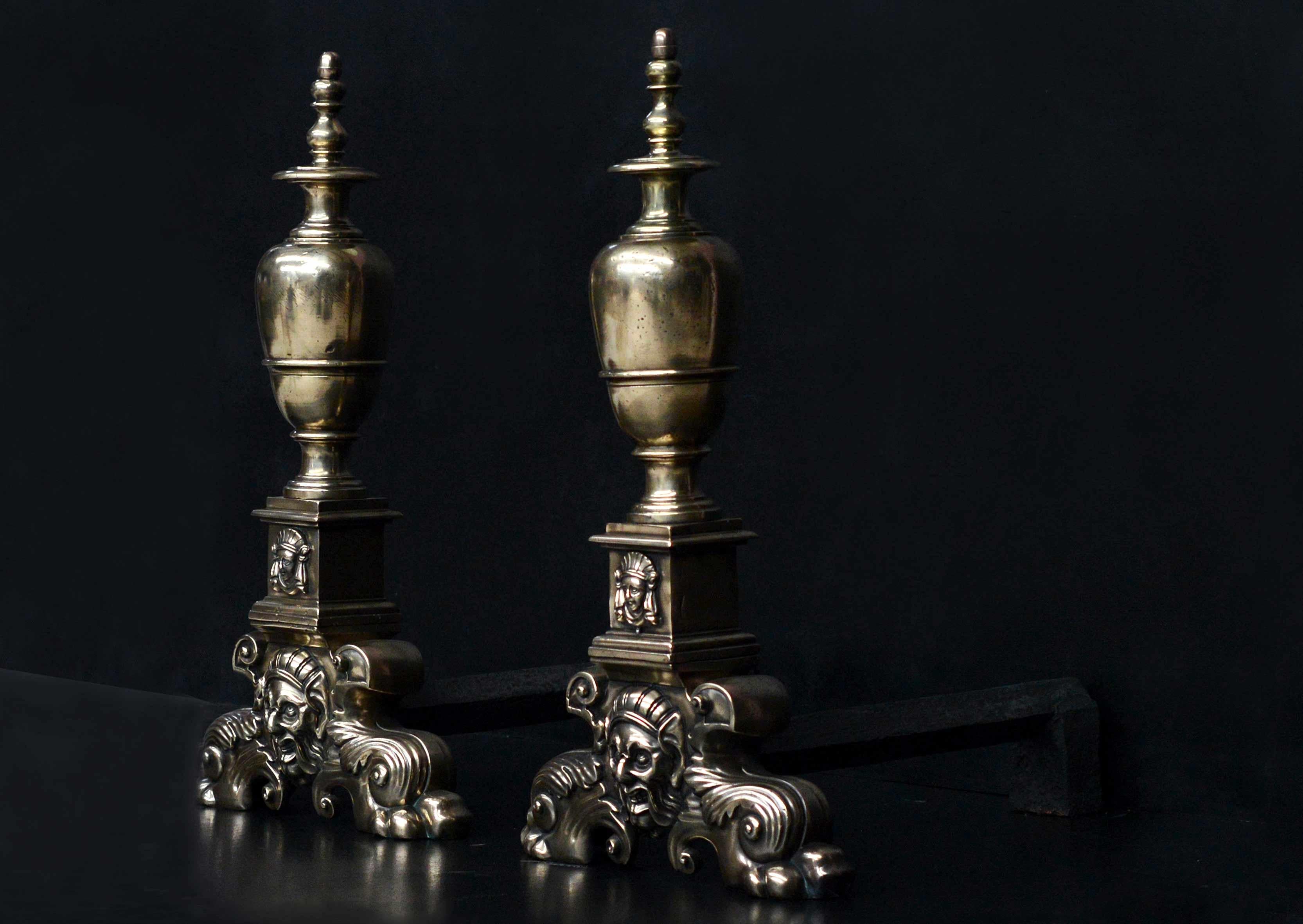 A pair of large Baroque style brass firedogs. The cast brass splayed feet with foliage and mask to centre, surmounted by bulbous finials. English, 19th century.

Measures: Height: 780 mm 30 3/4 in
Width: 420 mm 16 1/2 in
Depth: 615 mm 24 1/4 in.