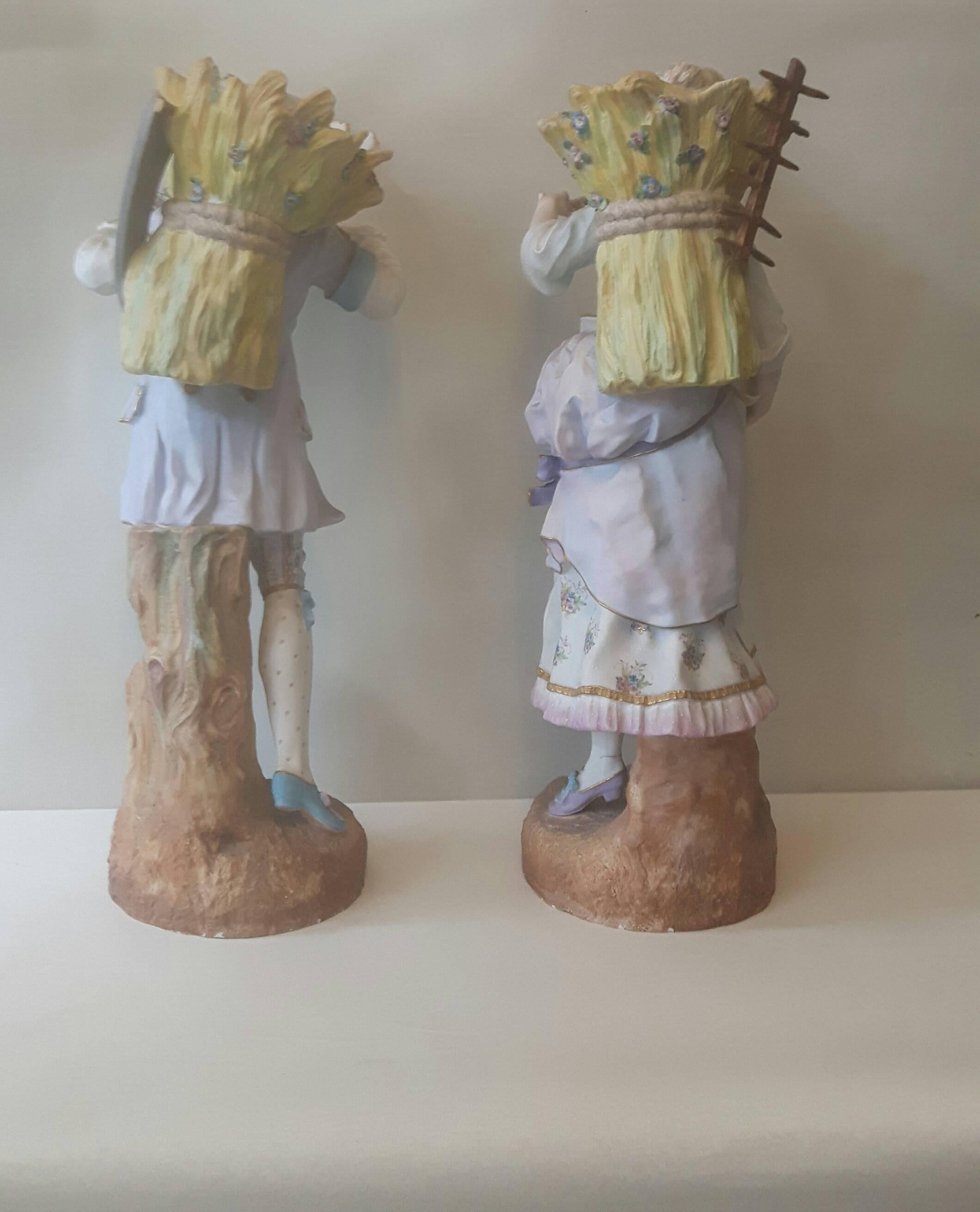 A pair of bisque porcelain figures of a courting couple in C18 dress, carrying wheat sheaves on their backs, she holding her hat with flowers in, her companion holding out a small bouquet of flowers to her.
French, circa 1890.