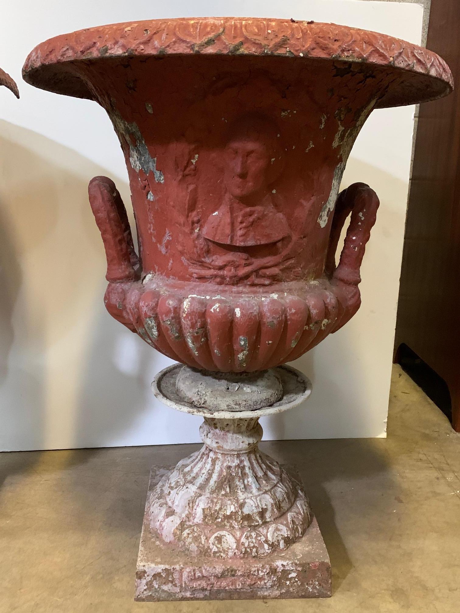 A large pair of American garden cast iron urns with a plaque of George Washington in a beautiful weathered red painted finish. 
The urns depict the first President of the United States , perfect for a historical home or anyone who is a fan of