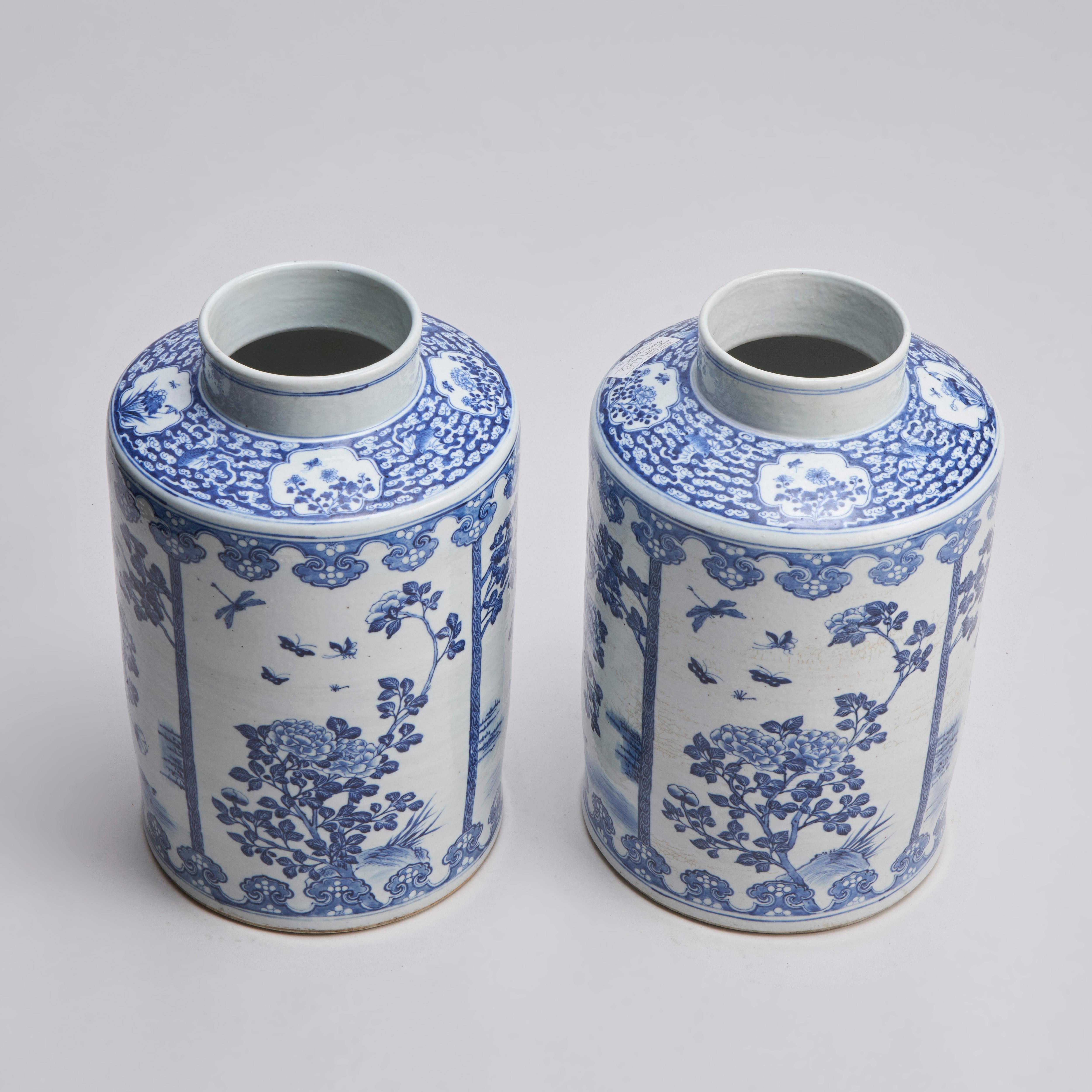 A large pair of 19th century Chinese blue and white cannisters with finely painted decoration of panels of peonies blooming one over a duck pond and another with butterflies and dragonflies circling.

The neck with miniature panel of peonies and
