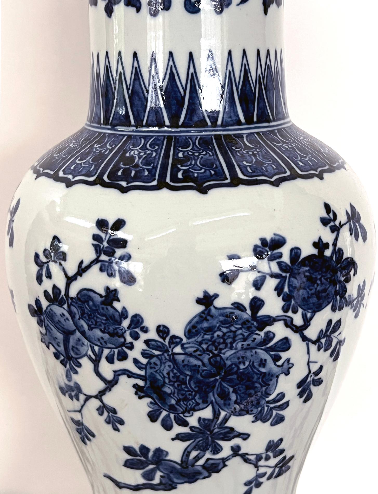 each tall vase with flaring neck above a bulbous body ending in a splayed foot; adorned overall with hand-painted lappet perimeter bands and floral vines; raised on custom wooden painted bases