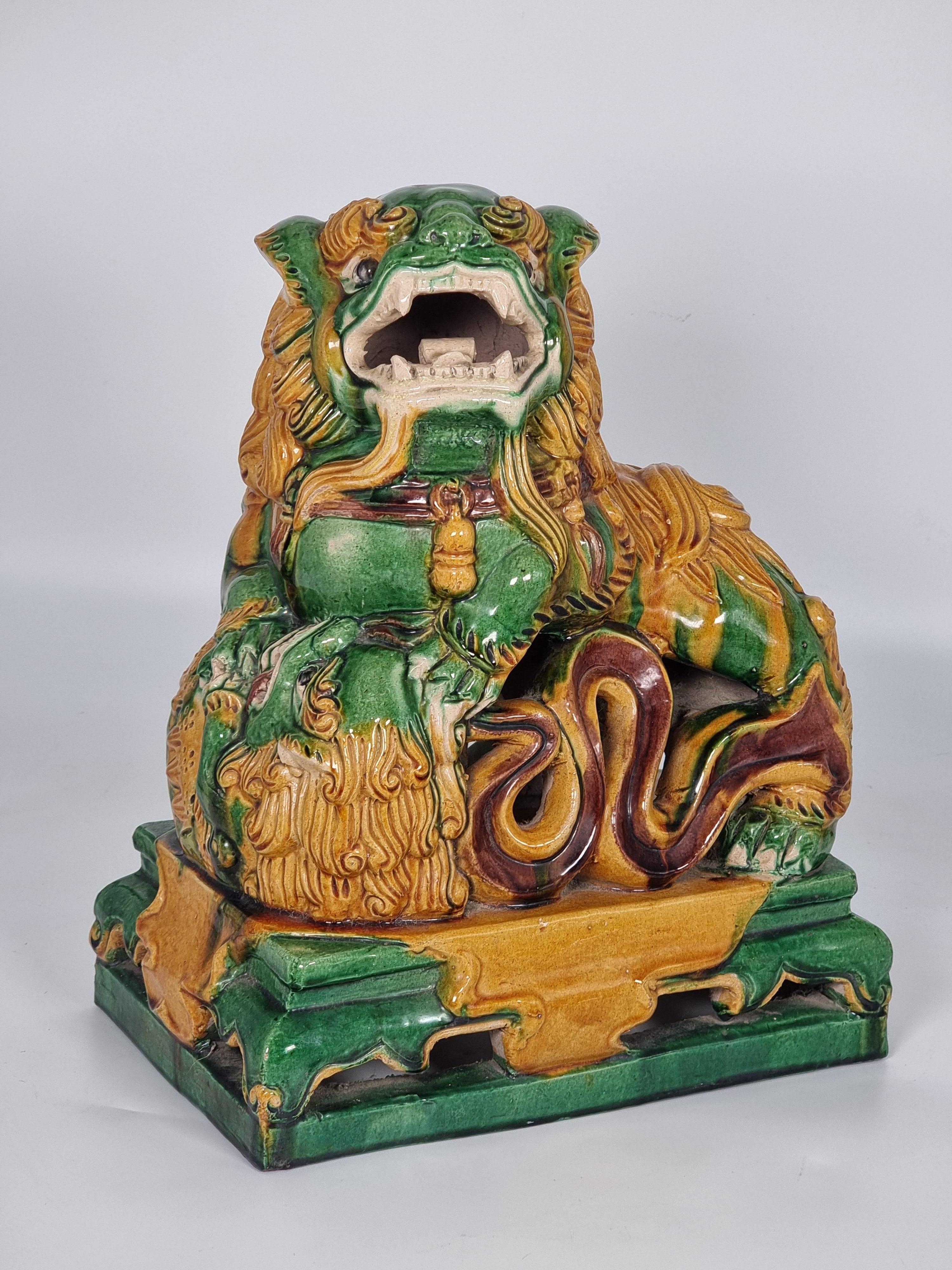 A pair of large late 19th century Chinese sancai glazed pottery dogs of foo in traditional colours of green, mustard and brown.

The pair of figures stand on raised rectangular bases which represent a low table draped with cloth. The decorative foo