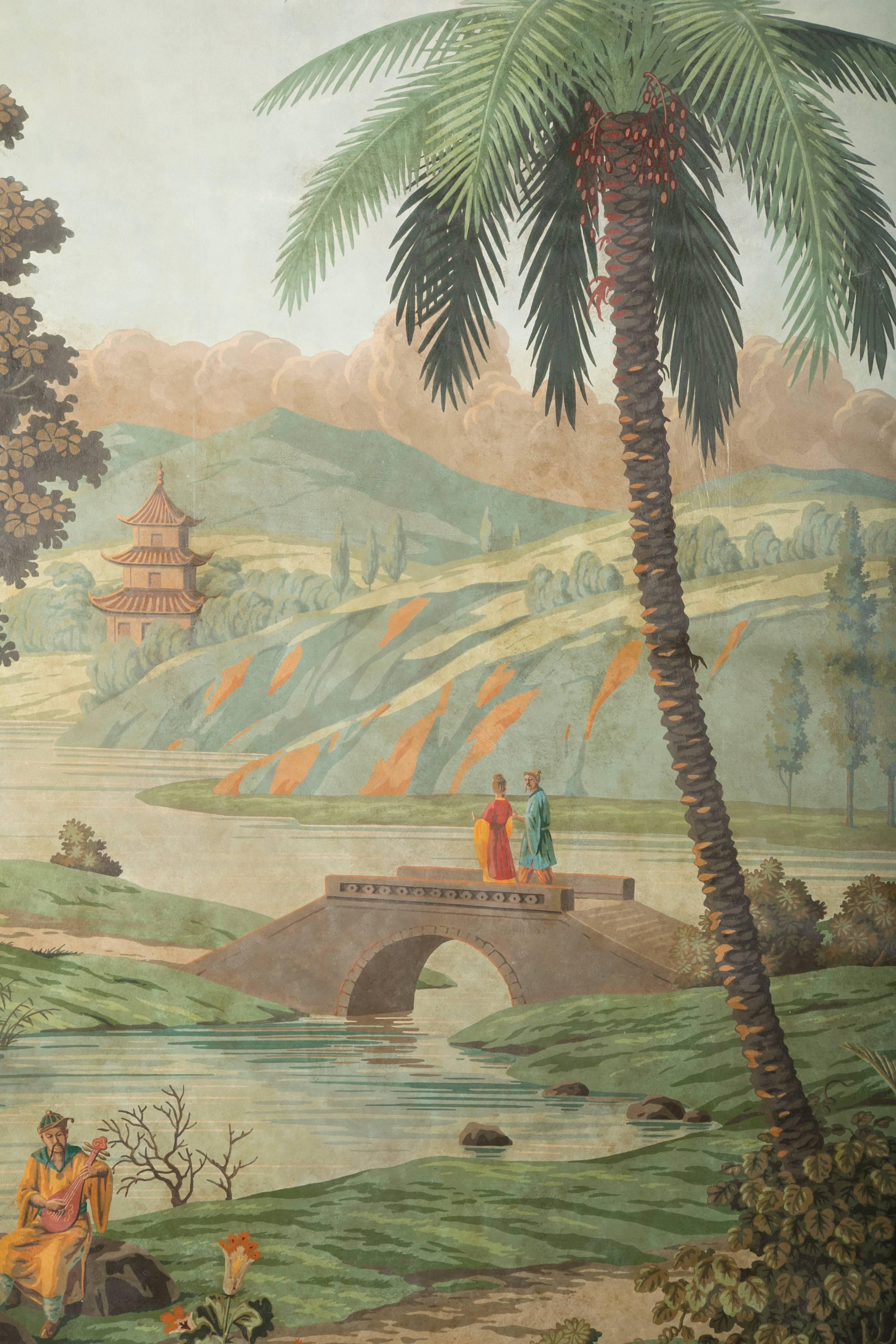 A pair of large French, Zuber wallpaper panels from the first half of the 20th century. Depicting chinoiserie scenes with palm trees in the background. Now framed in 18-karat yellow gold frames with ebonized sides.