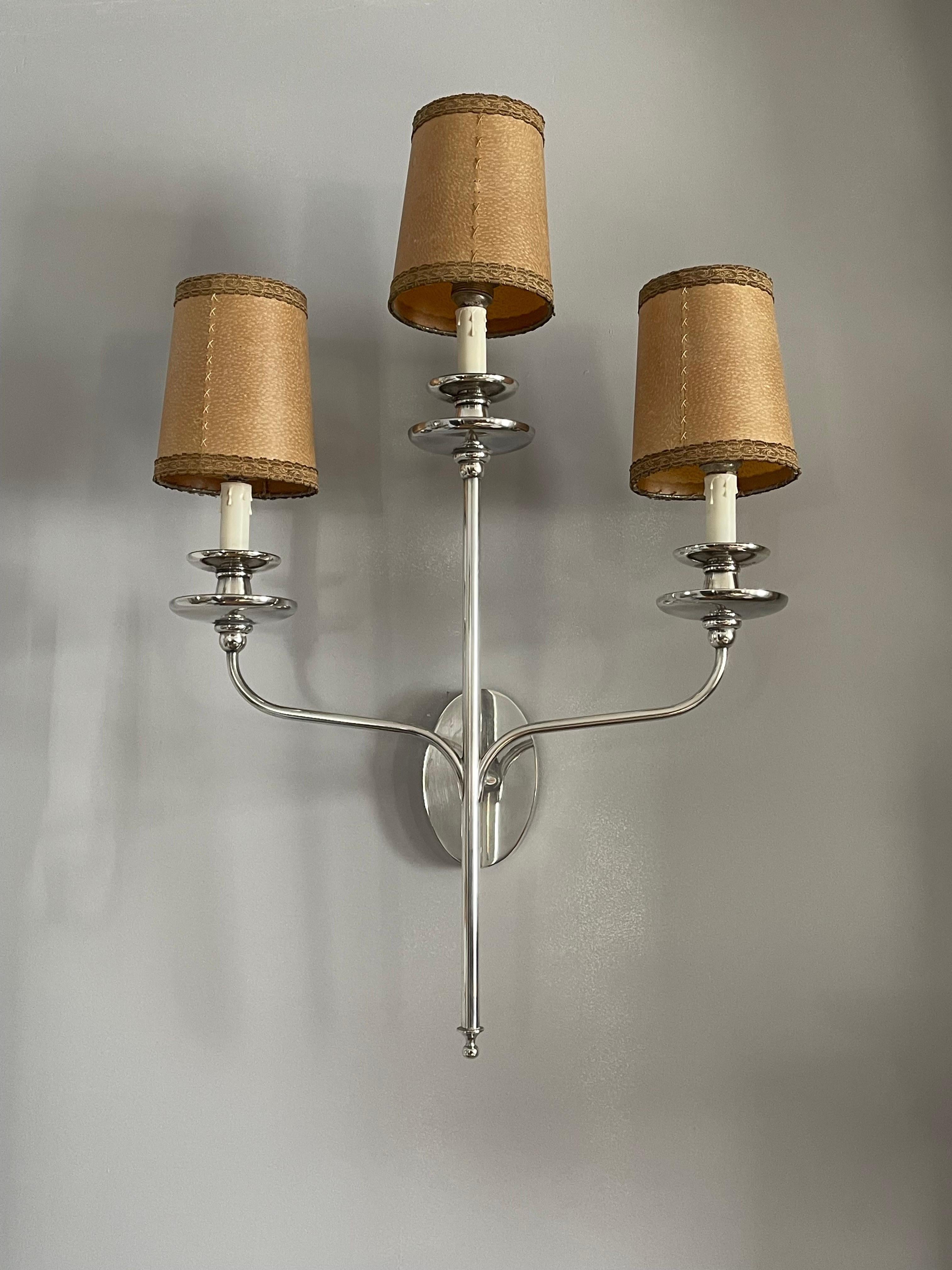 A Large Pair of American Art Deco silver plated wall sconces with original parchment hand stitched shades. 
The 900 silver plating on bronze is in great condition with exception of one one inch long scratch down to the bronze. 
They have been