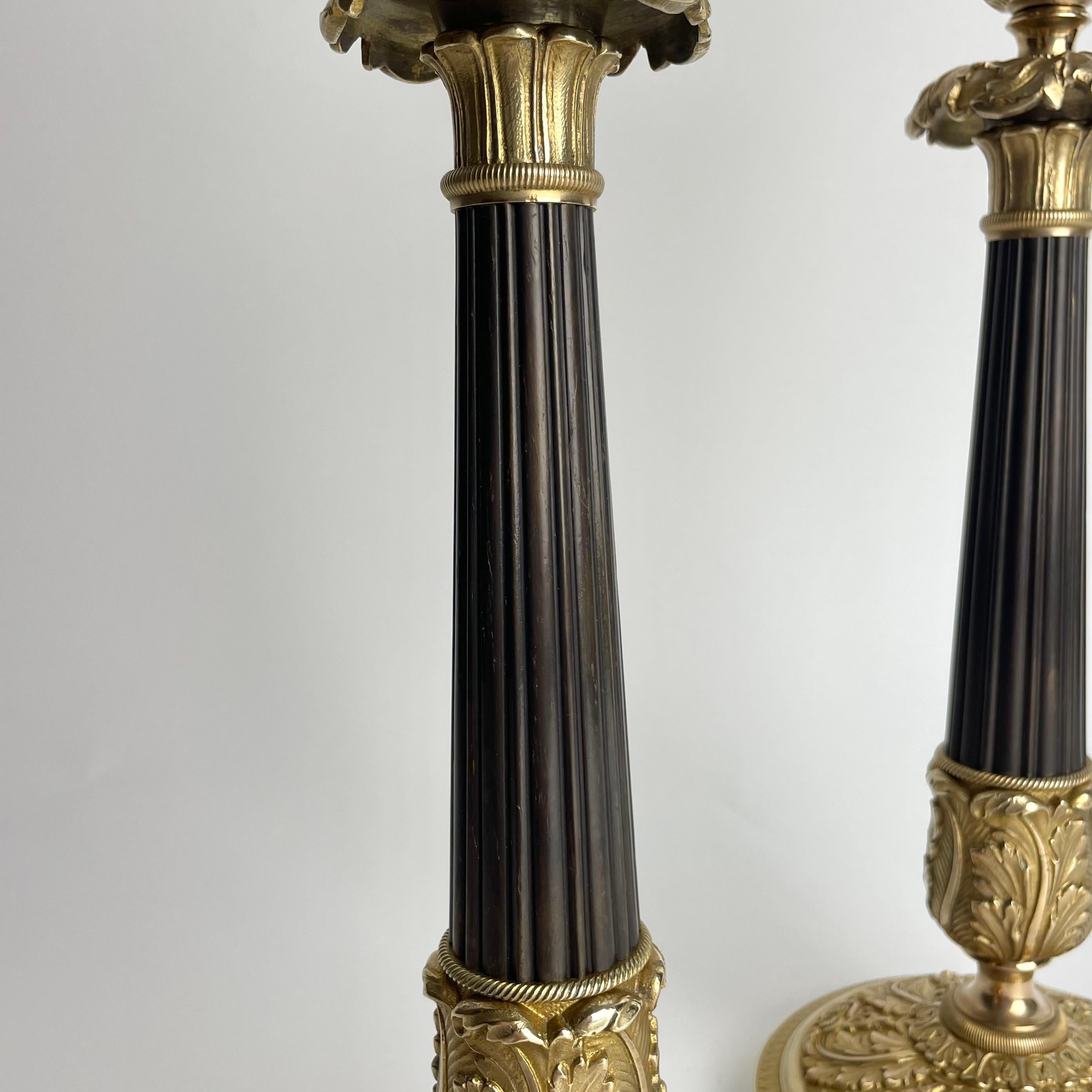 Gran pareja de candeleros Imperio en bronce dorado y patinado oscuro. 1820s principios del siglo XIX en venta