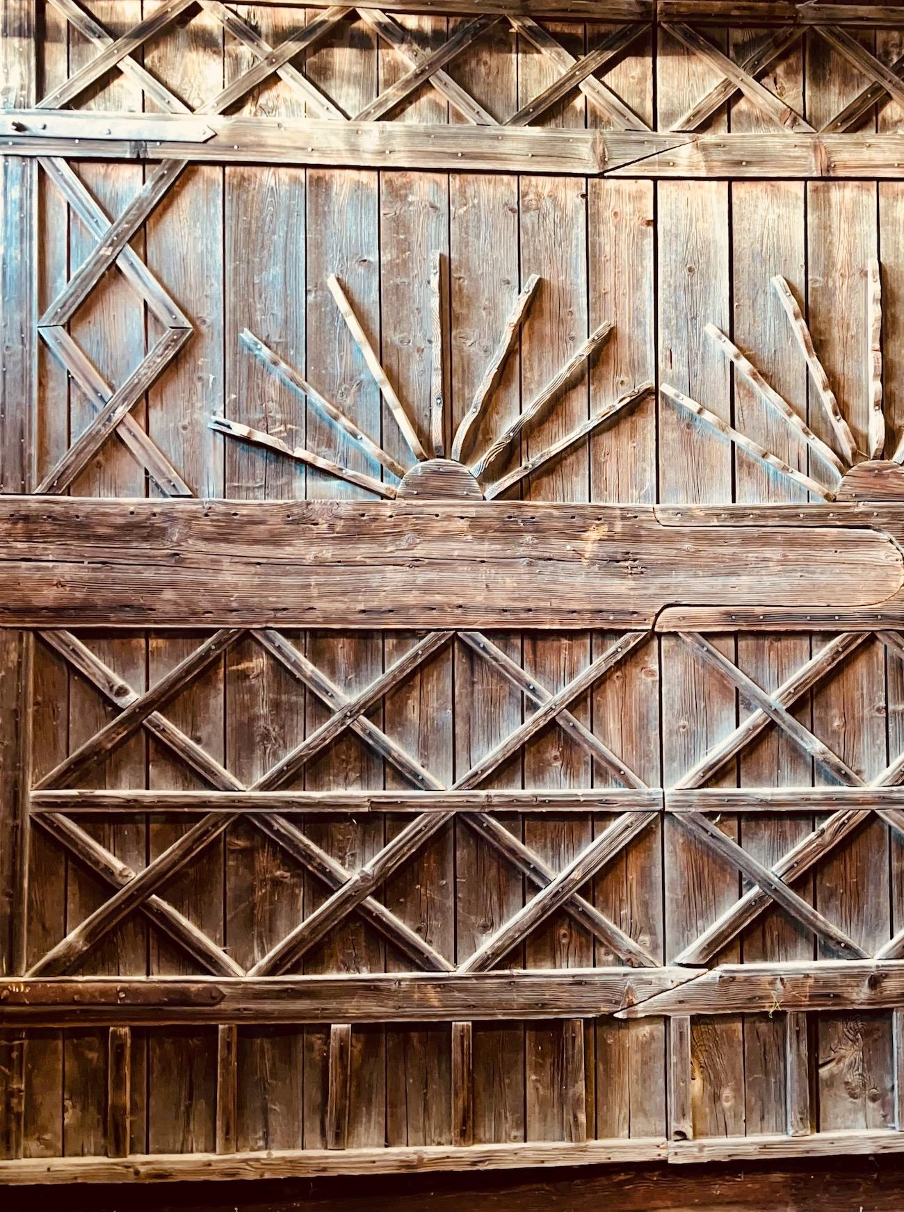 A  beautiful pair of very large interlocking hardwood barn doors which have been in storage in a 19th C. New England barn for many many years. Each door is very intricately and beautifully decorated on their interior sides with a lattice and