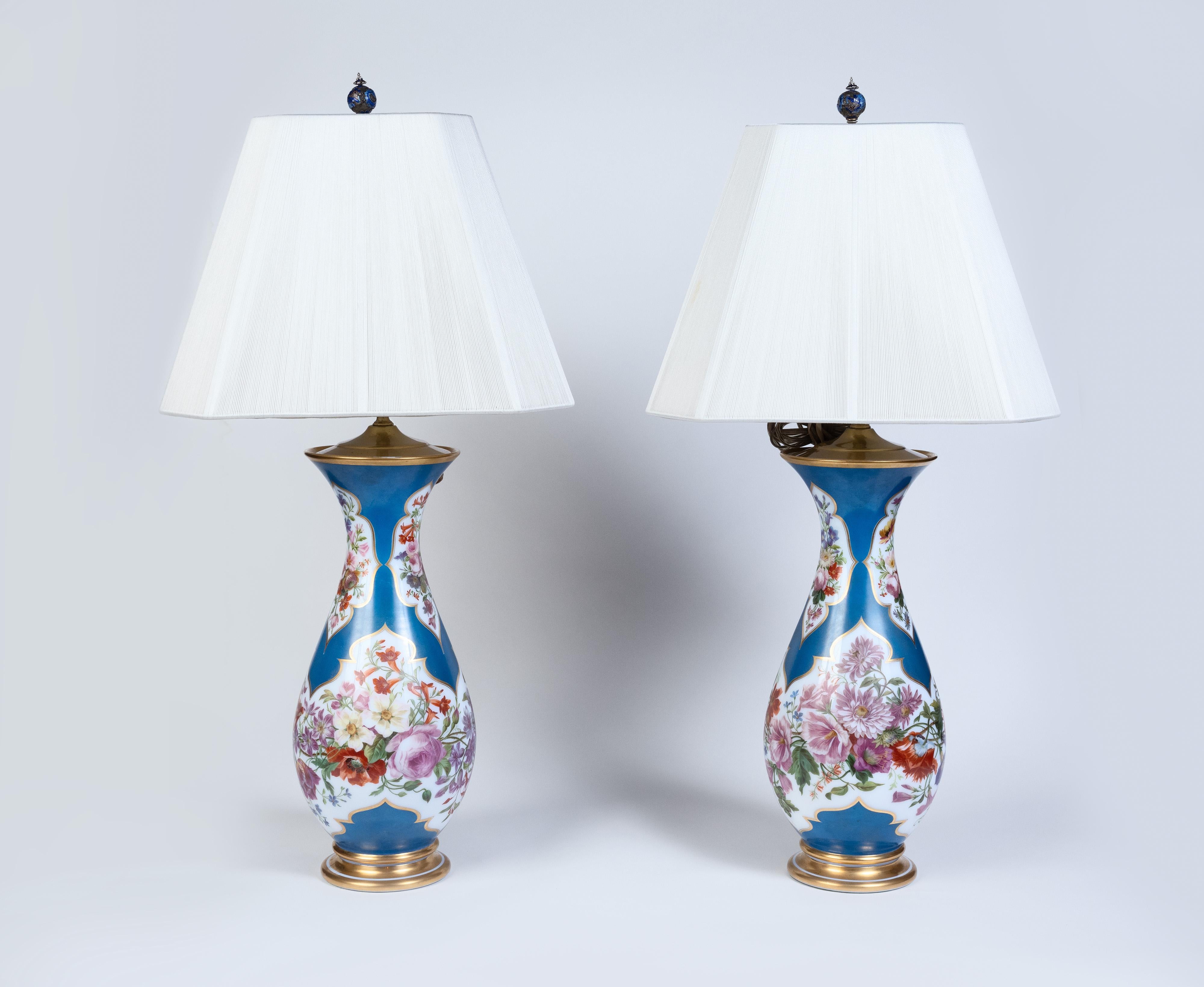 A Large Pair of French Baccarat Opaline Glass Vases / Lamps, 19th Century, Circa 1870

These opulent lamp / vases are adorned with meticulous hand-painted floral motifs, showcasing the delicate craftsmanship characteristic of Baccarat. The opaline