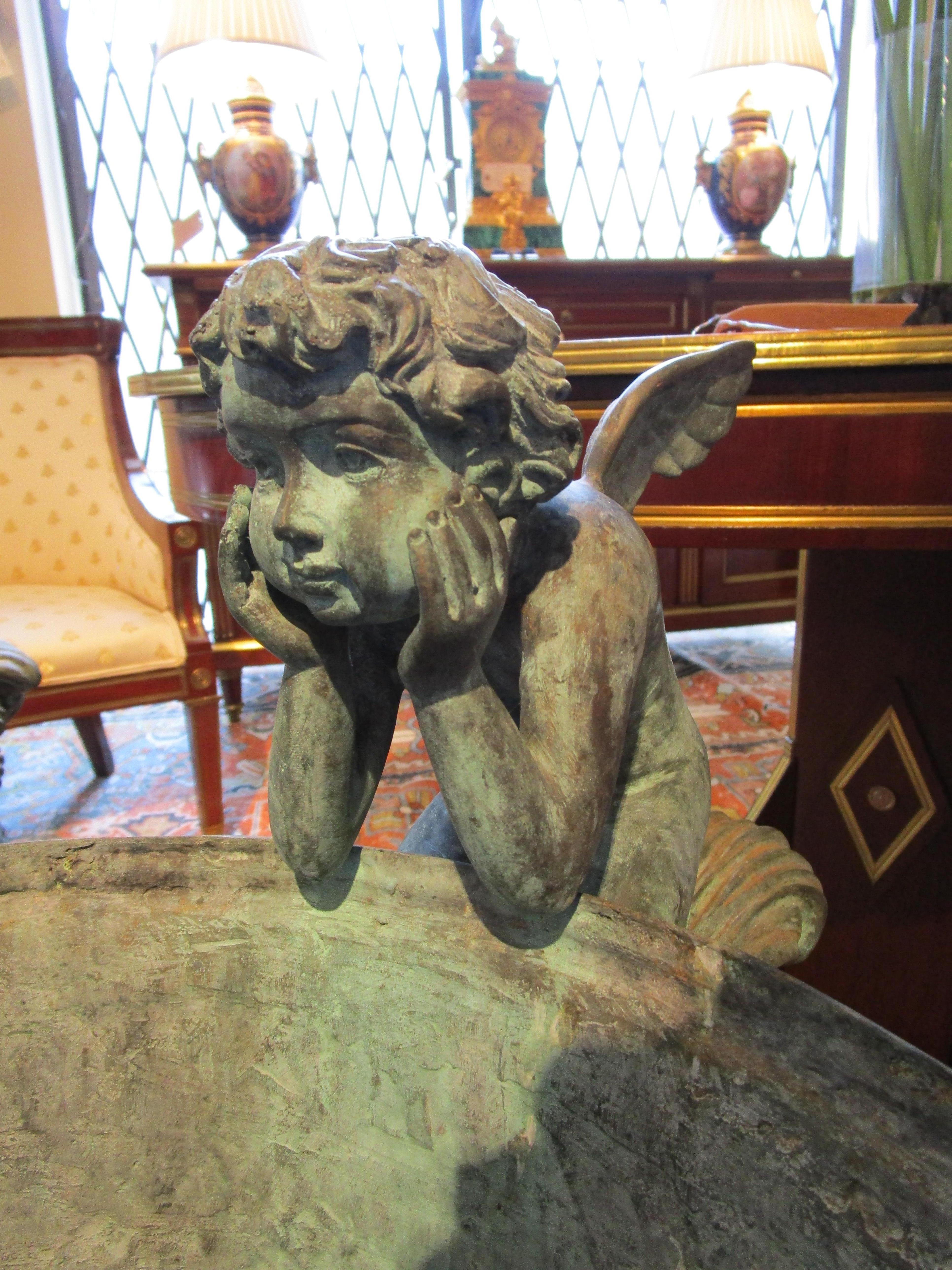 A large and fine pair of early 20th century French bronze garden urns with cherubs and lions heads. Beautifully cast and weathered. From a prominent Ny estate.