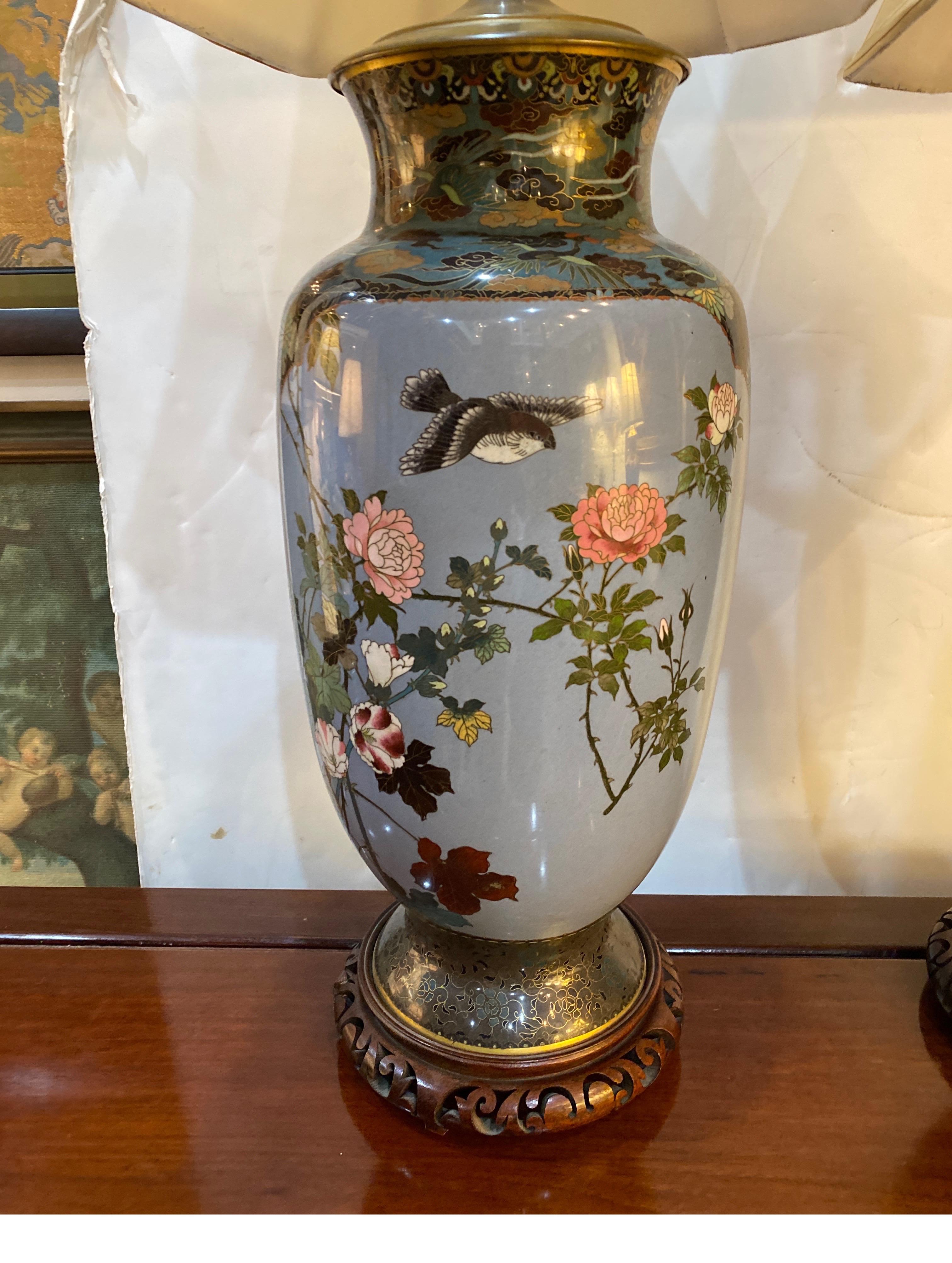 A large pair late Meiji period Japanese Cloisonné vases now as lamps. The enamel work is exceptional with cartouches on birds and florals on both sides. The shades are for photographic purposes only and not included.