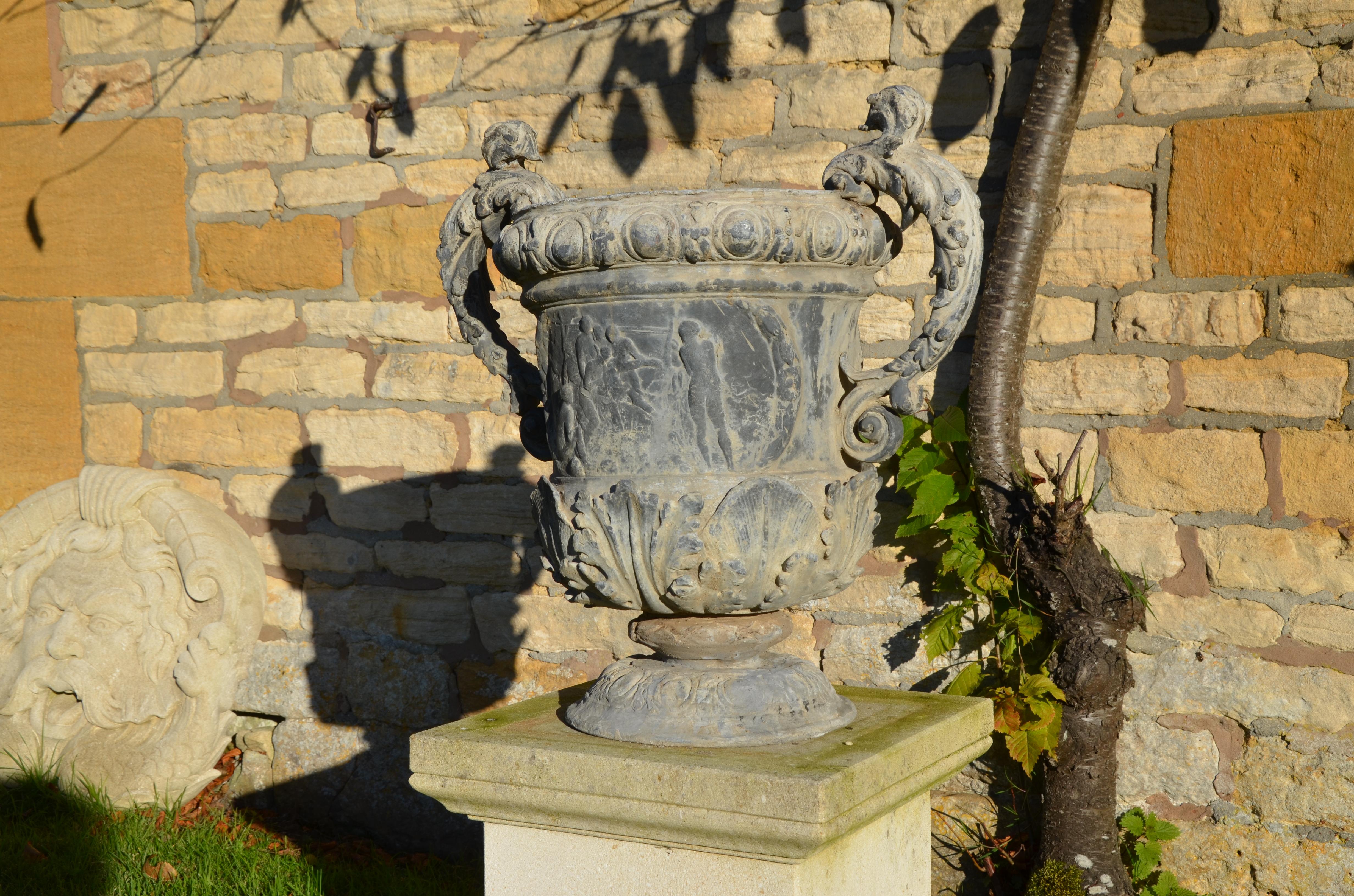 The main body decorated with allegorical scenes and acanthus leaf decoration, having foliate handles raised upon a decorative circular base.