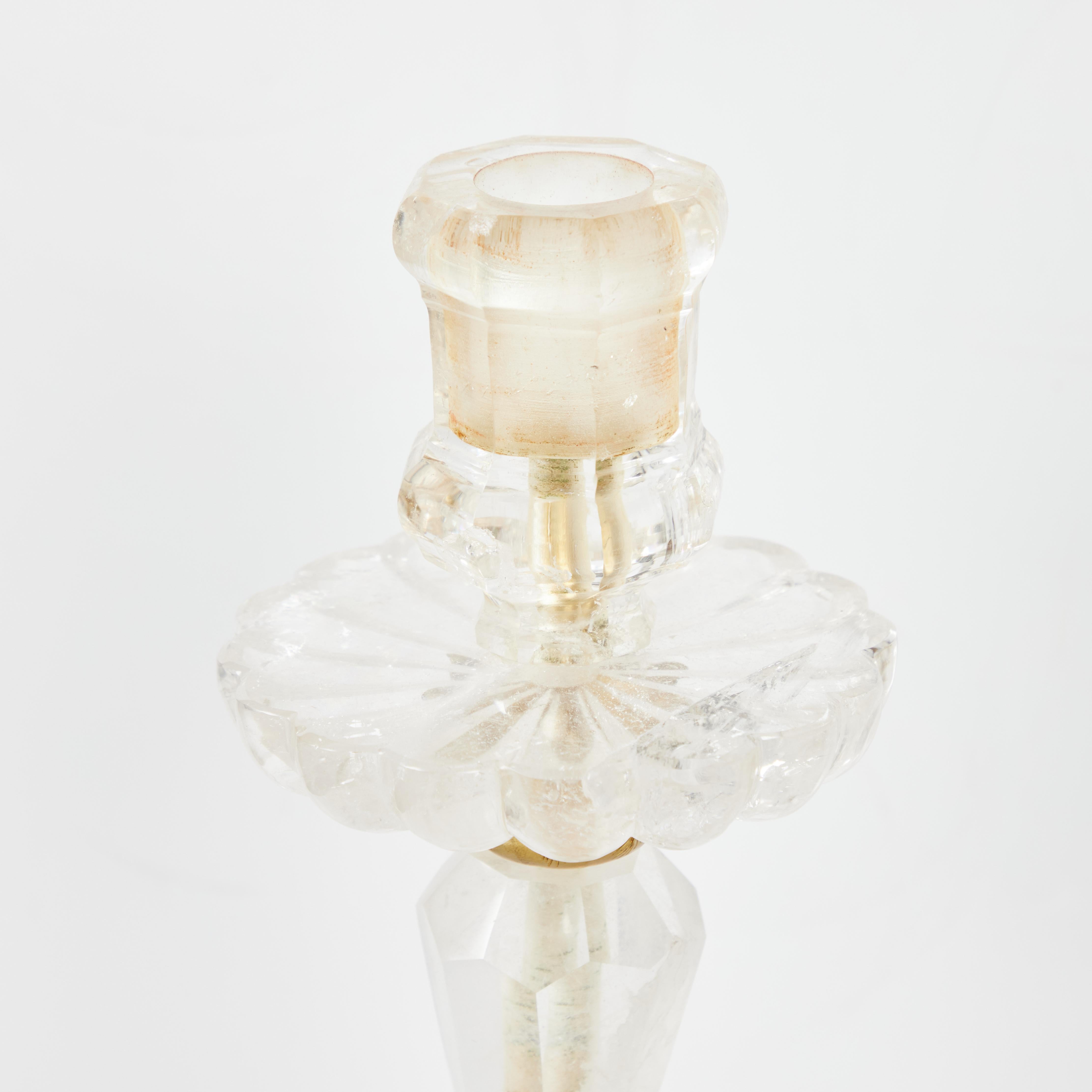 Pair of grand and elegant rock crystal candlesticks with brass mounts.  Scalloped bobeche.  Individual pieces of rock crystal assembled with a brass center rod.  Ball feet.  Modern fabrication.