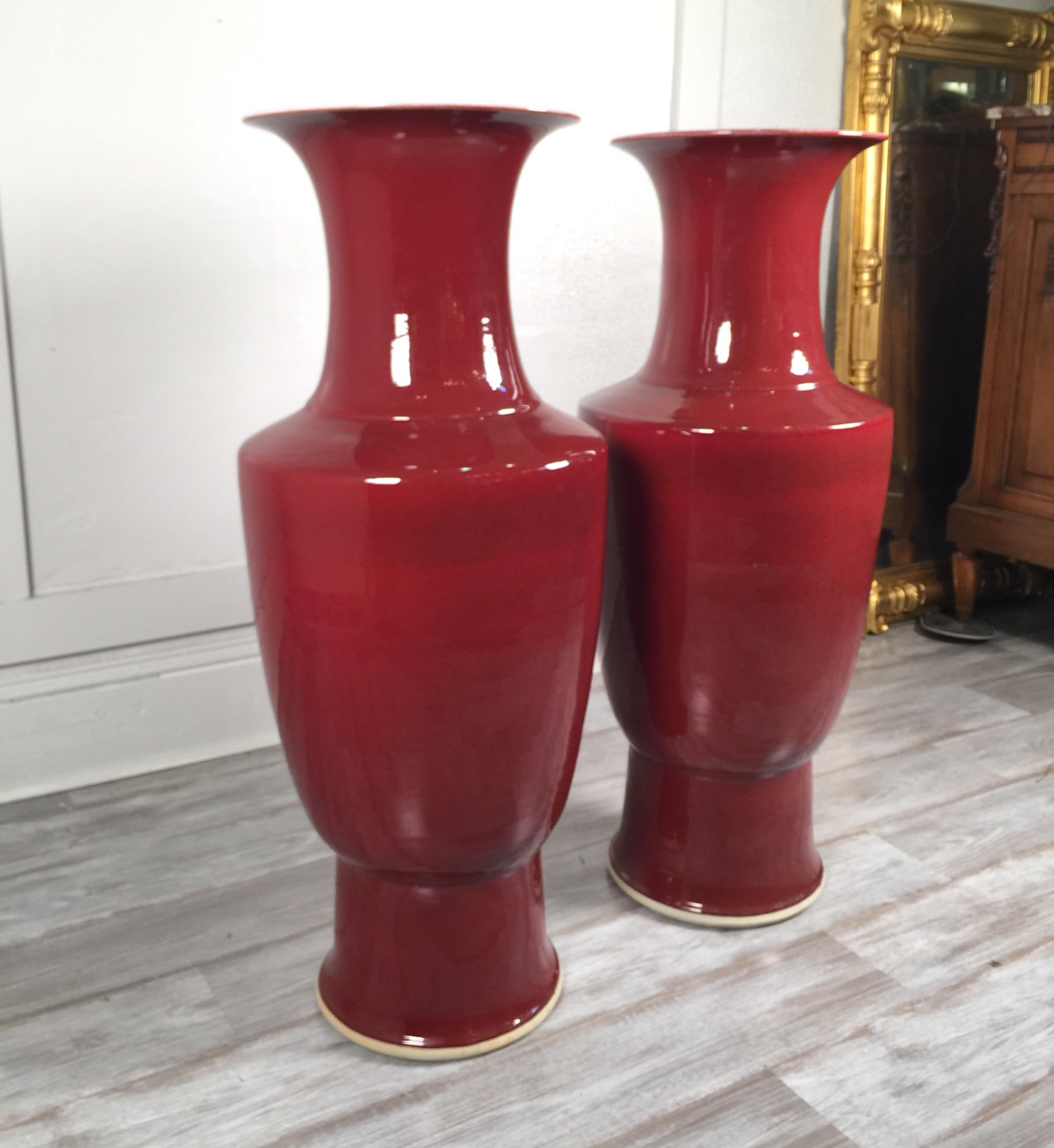 Impressive pair of Chinese porcelain Sang-de-Boeuf 3 ft tall floor vases.
Also called flambé glaze, a glossy, rich, blood red glaze often slashed with streaks of purple or turquoise used to decorate pottery, particularly porcelain. The effect is
