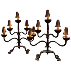 A large pair of wrought iron candelabra table lamps with copper shades