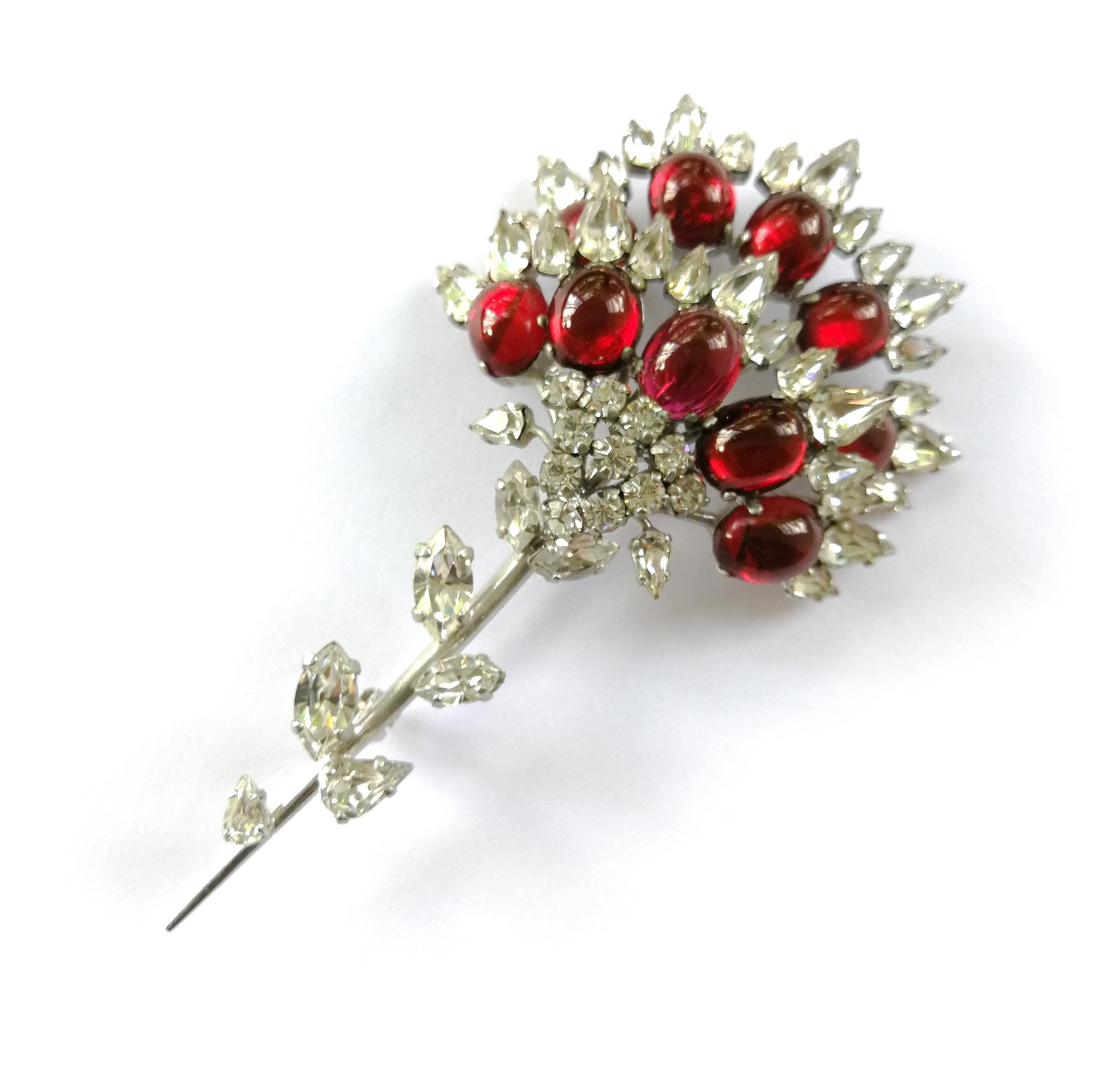 A splendid stylised floral brooch, designed by Francis Winter, the great early designer for Christian Dior, and made in Germany by Henkel and Grosse, marked '1960'. It is made of ruby paste cabuchons and clear paste, some open backed, others prong