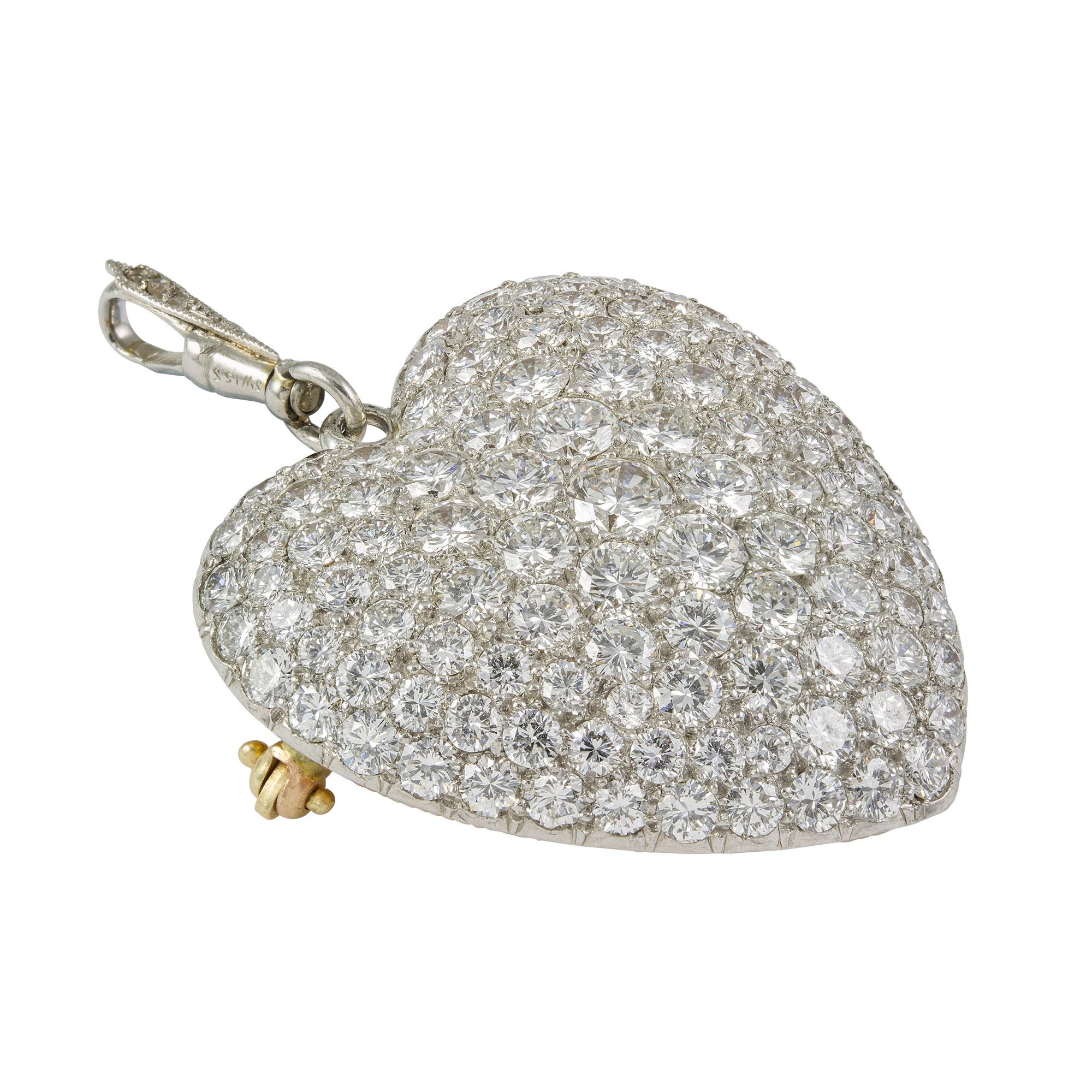 A diamond set heart brooch/pendant, pave set with round brilliant-cut diamonds, estimated to weigh 6.5 carats in total, all in white mount with heart shape glass locket compartment on reverse, within a fluted gold frame with a diamond set diamond