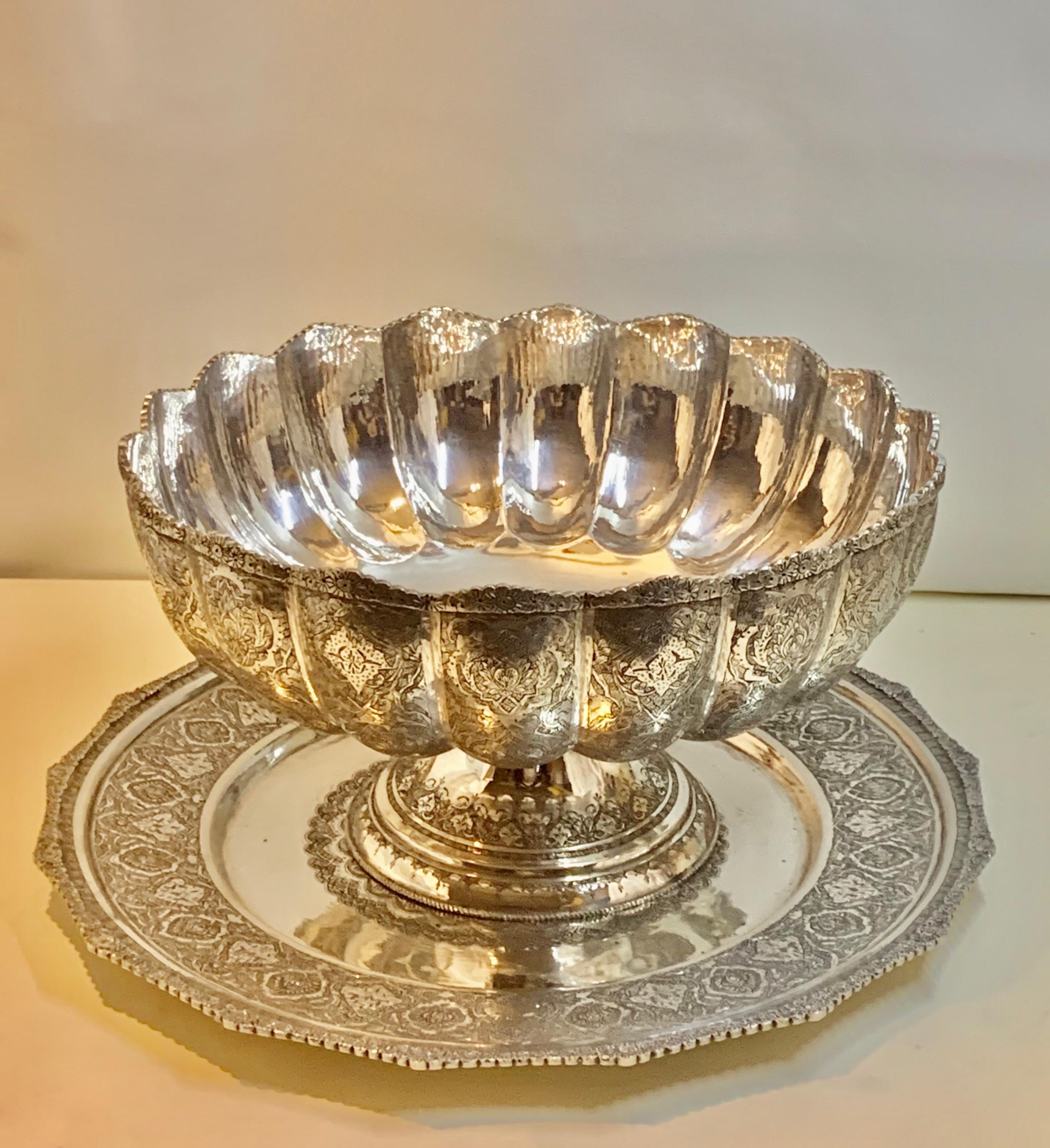 A huge antique early-20th century Persian sterling silver bowl and tray the body is deeply fluted all around. This is profusely engraved with different floral scenes and surrounded by floral motifs on a finely tooled background. The engraving is of