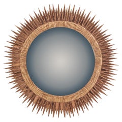 Un gran espejo convexo de cristal rosa y resina, con diseño "Soleil à Pointes".
