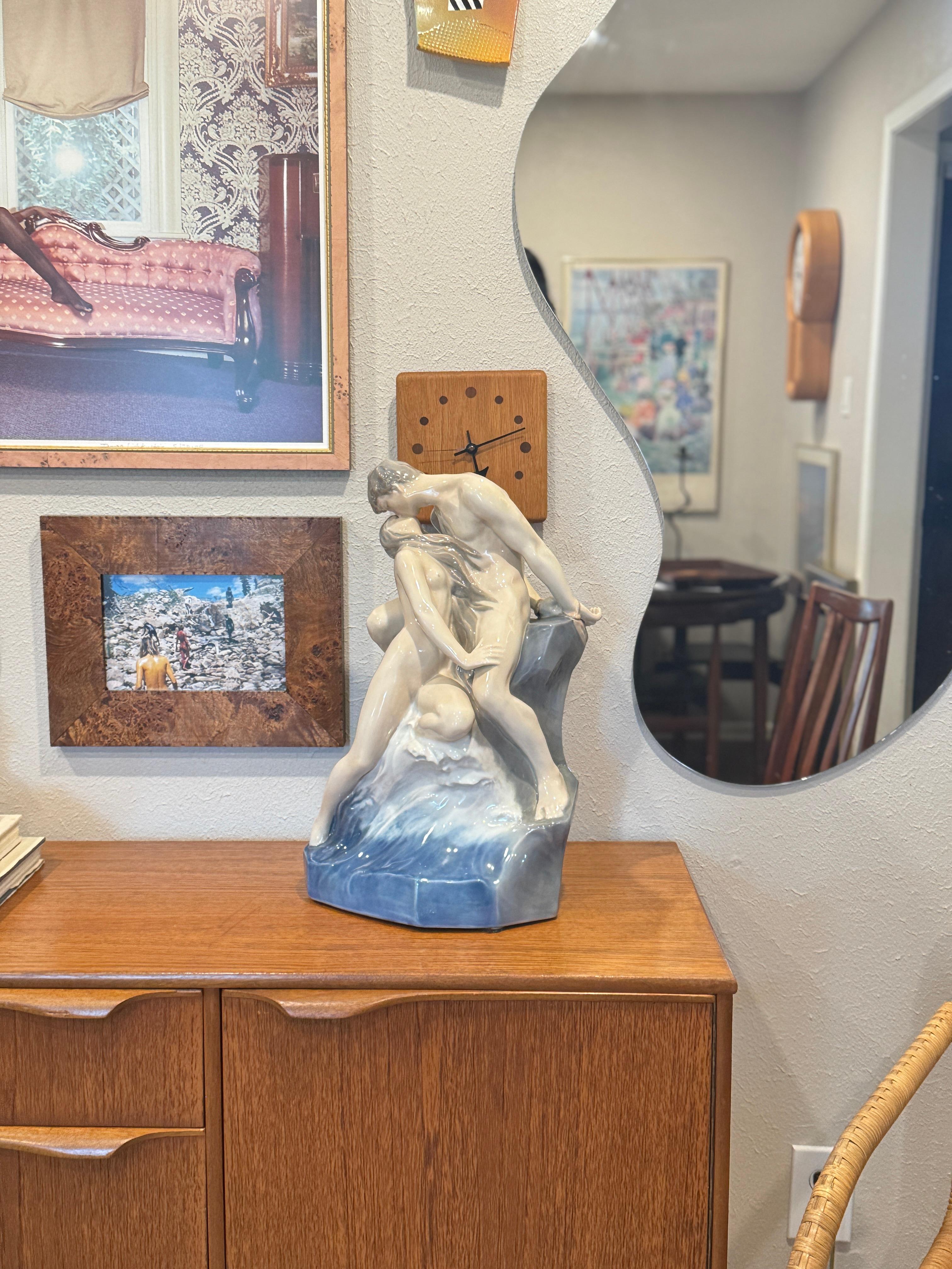Una gran escultura de porcelana increíblemente romántica de una pareja besándose junto al mar llamada 
