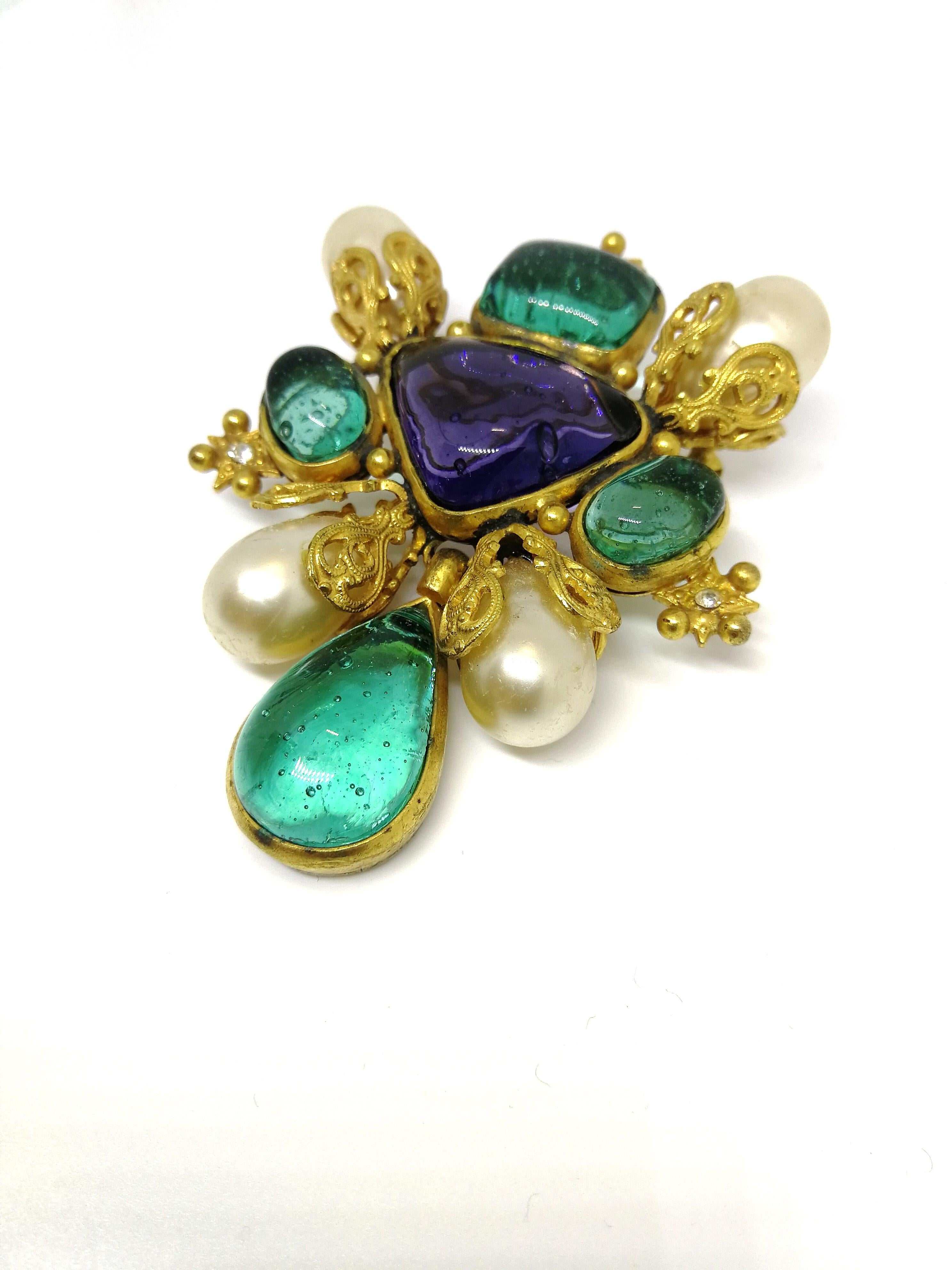 This is a very beautiful brooch, classic Chanel, and an exceptional design by Victoria de Castellane for Chanel. Designed with signature gilt filigree caps, in which sit  baroque pearls, and emerald and amethyst poured glass cabuchon panels and