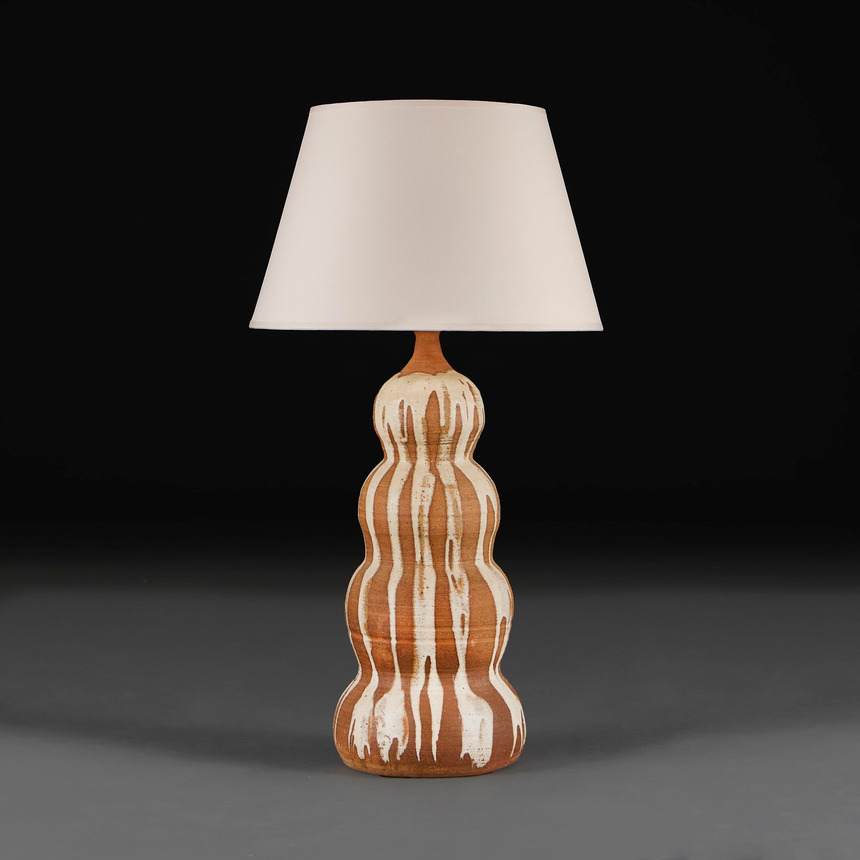 France, circa 1960

A mid twentieth century art pottery vase of large scale, the quadruple gourd form overlaid with a cream drip glaze, now as a lamp.

Height of vase          58.00cm
Height with shade   87.00cm
Diameter of base    23.00cm

Please