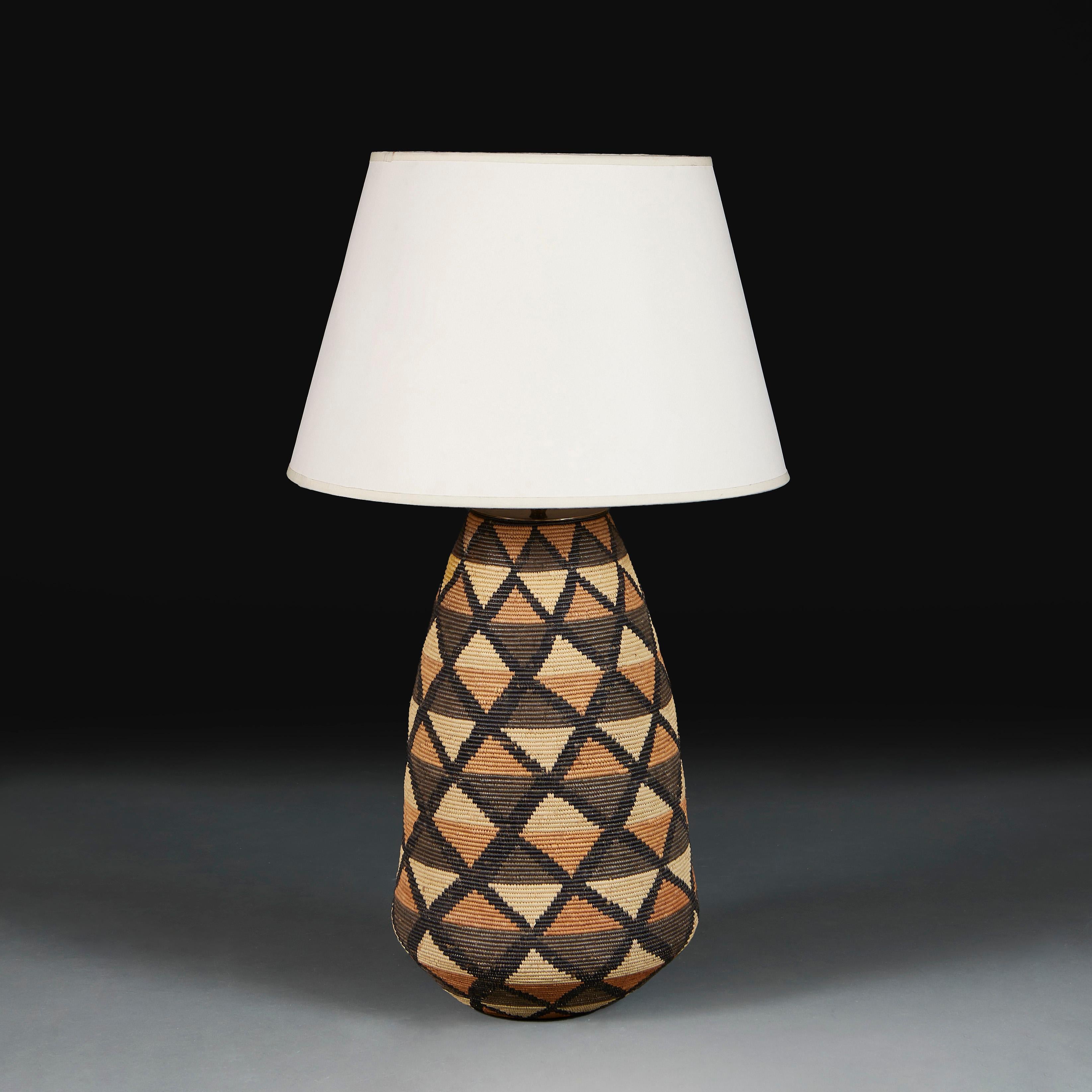 South Africa, circa 1960

An unusual raffia woven basket vase of large scale with a repeating geometric pattern, now converted as a lamp. 

Height of vase 47.00cm

Diameter of base 27.00cm

Photographed with a 18” diameter Pembroke card