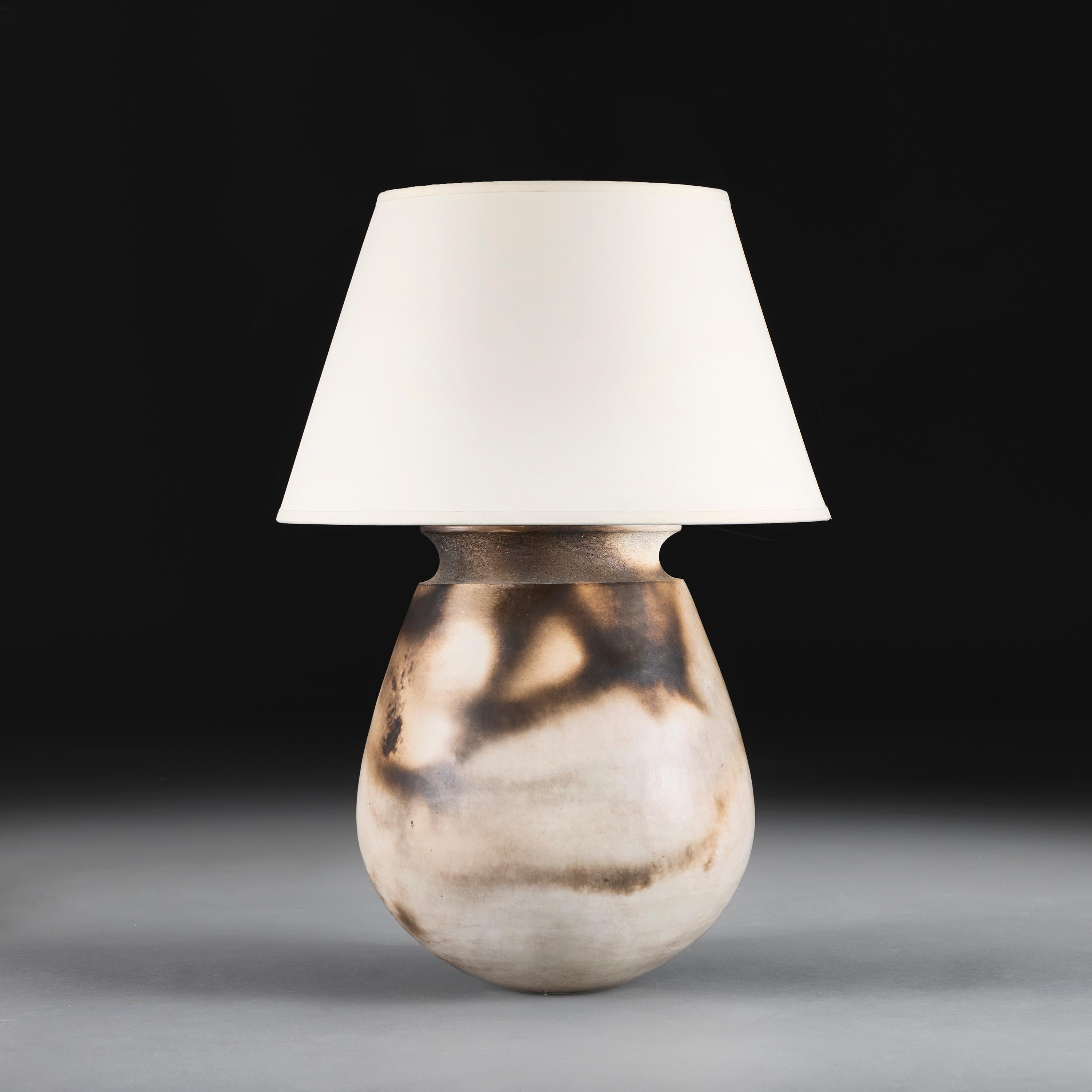 Angleterre, vers 1960

Un grand vase en céramique cuite au raku, dont le corps bulbeux de couleur crème est décoré de marques de fumée organiques, est maintenant monté comme lampe.

Hauteur 34.00cm

Largeur 29.00cm

Profondeur 27.00cm

Veuillez
