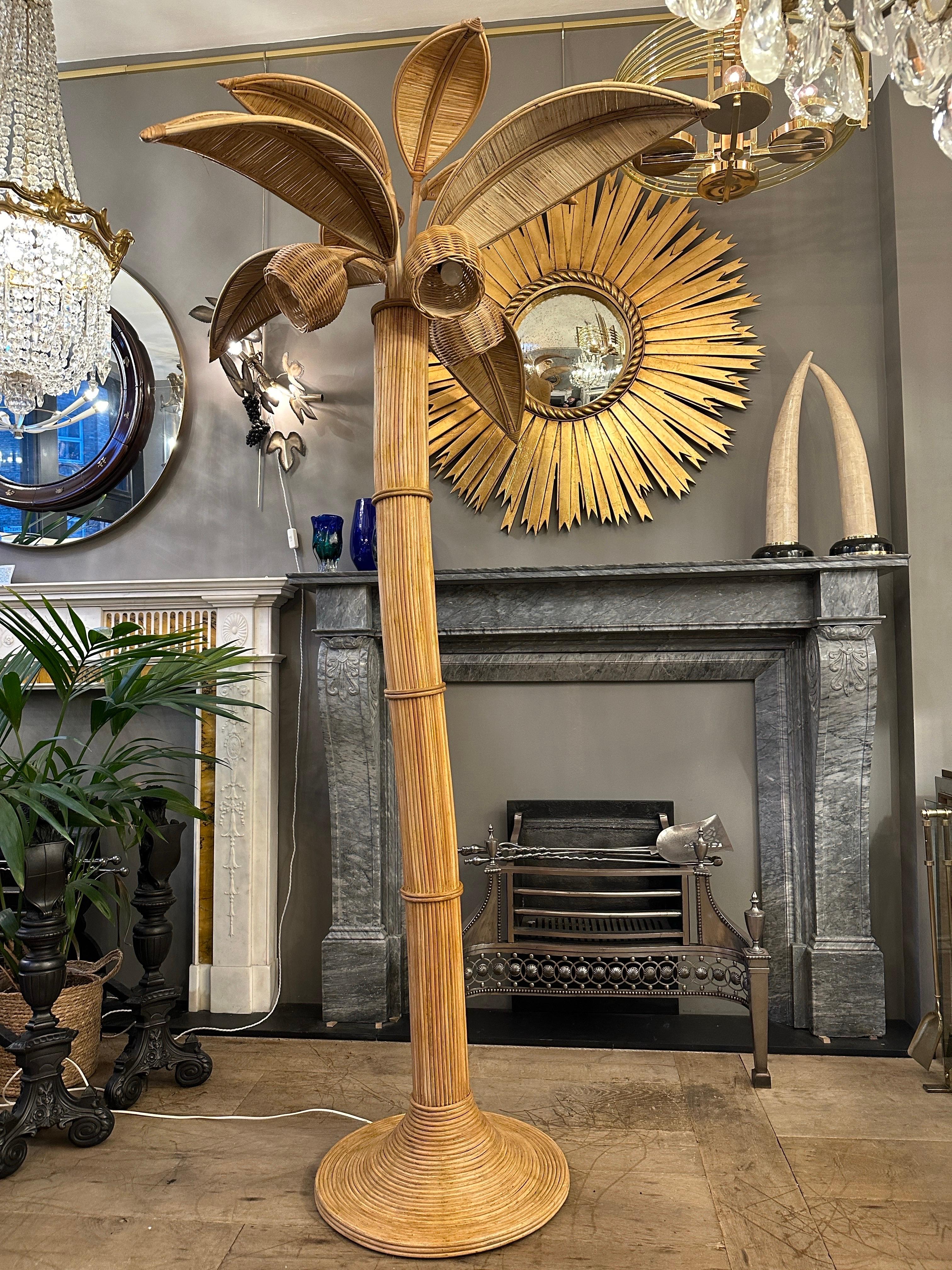 A very large reeded rattan palm/coconut tree. Very French Riviera in style late 20th century period. The wide circular base, supporting the organic shaped trunk which in turn holds 8 palm leafs and 3 coconut light bulb shades. Very good condition.
