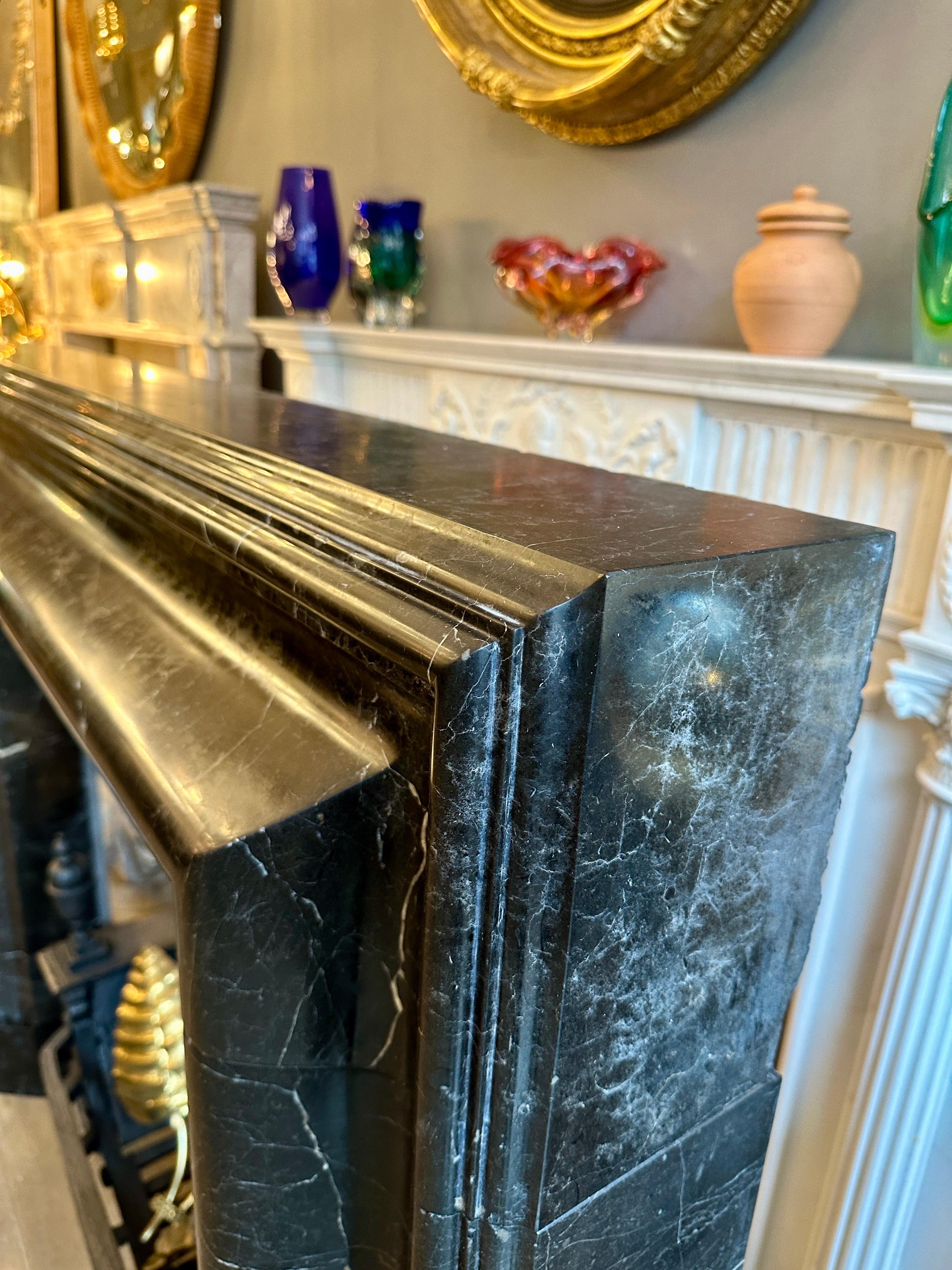 Carved A Large Reclaimed Black Marble Bolection Fireplace Mantel For Sale