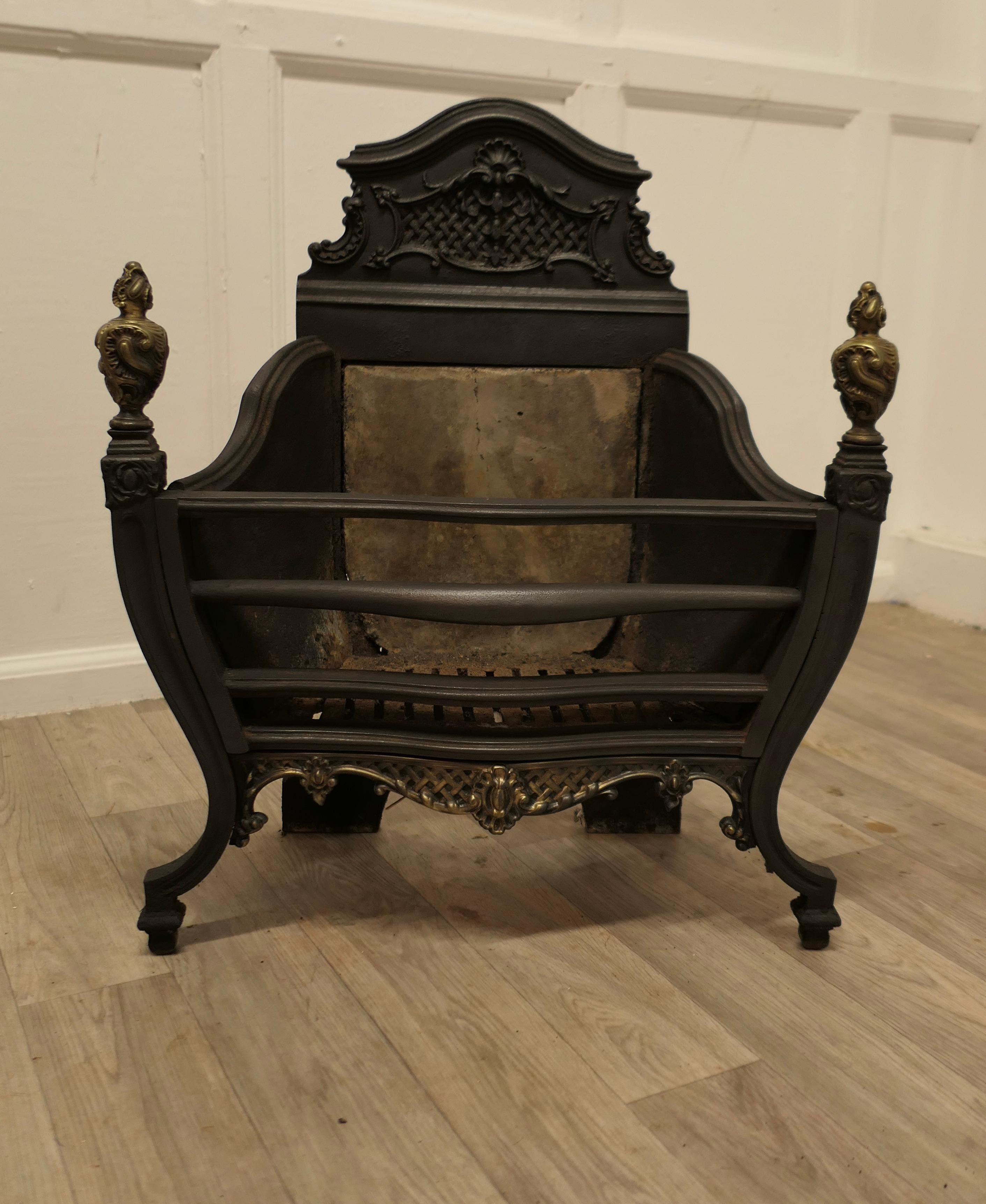 A Large Regency Iron Fire Grate
 
The fire has a decorative high back, in front there is a large fire basket which is in good sturdy condition.
The front of the fire has outward sweeping legs topped with turned brass finials matching the front