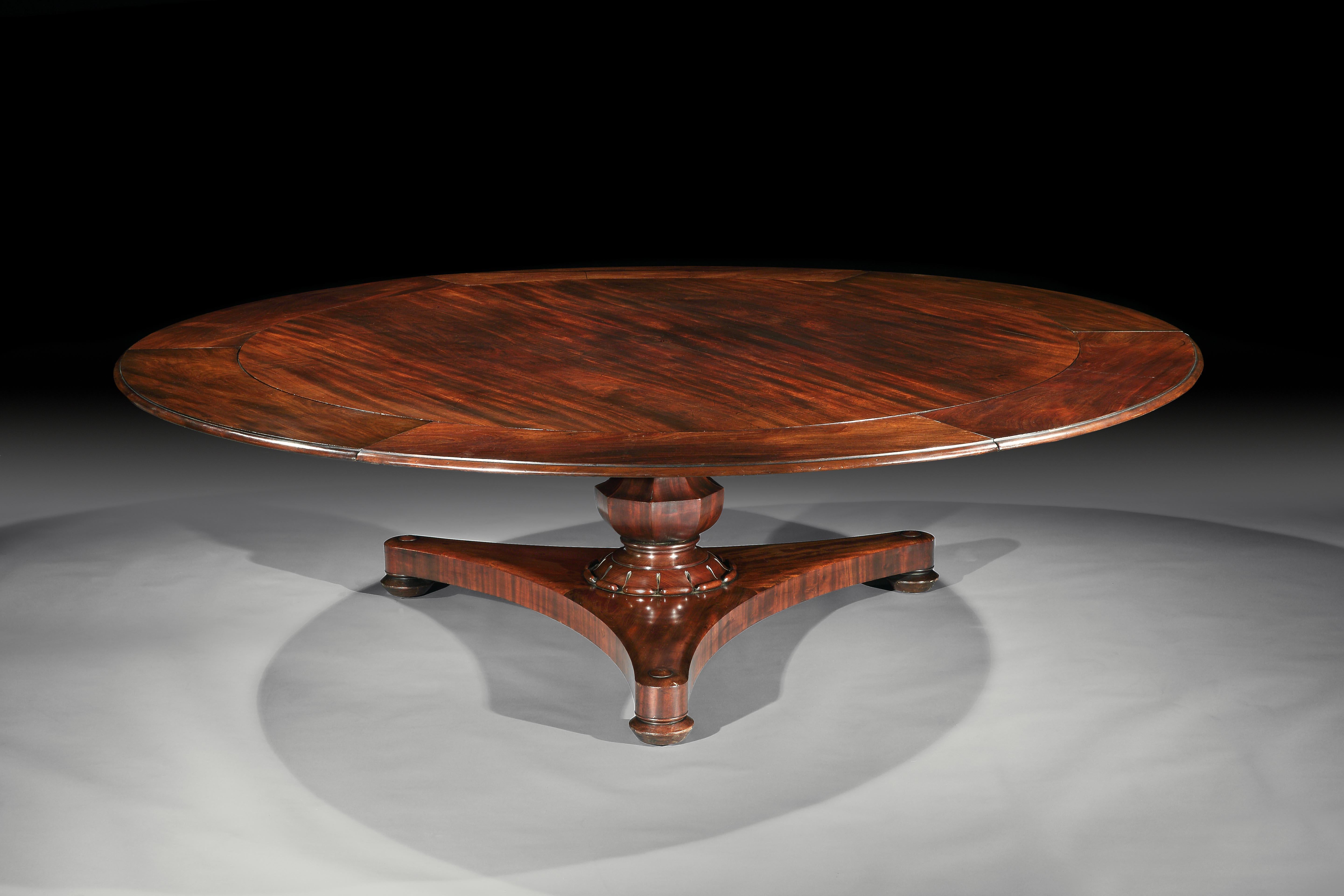 An extremely rare very large regency mahogany round dining table, resting on a turned central column, with lotus leaf carving, on a large plate-form base, with turned feet and concealed castors.
English, Circa 1835
Measures: Diameter, without