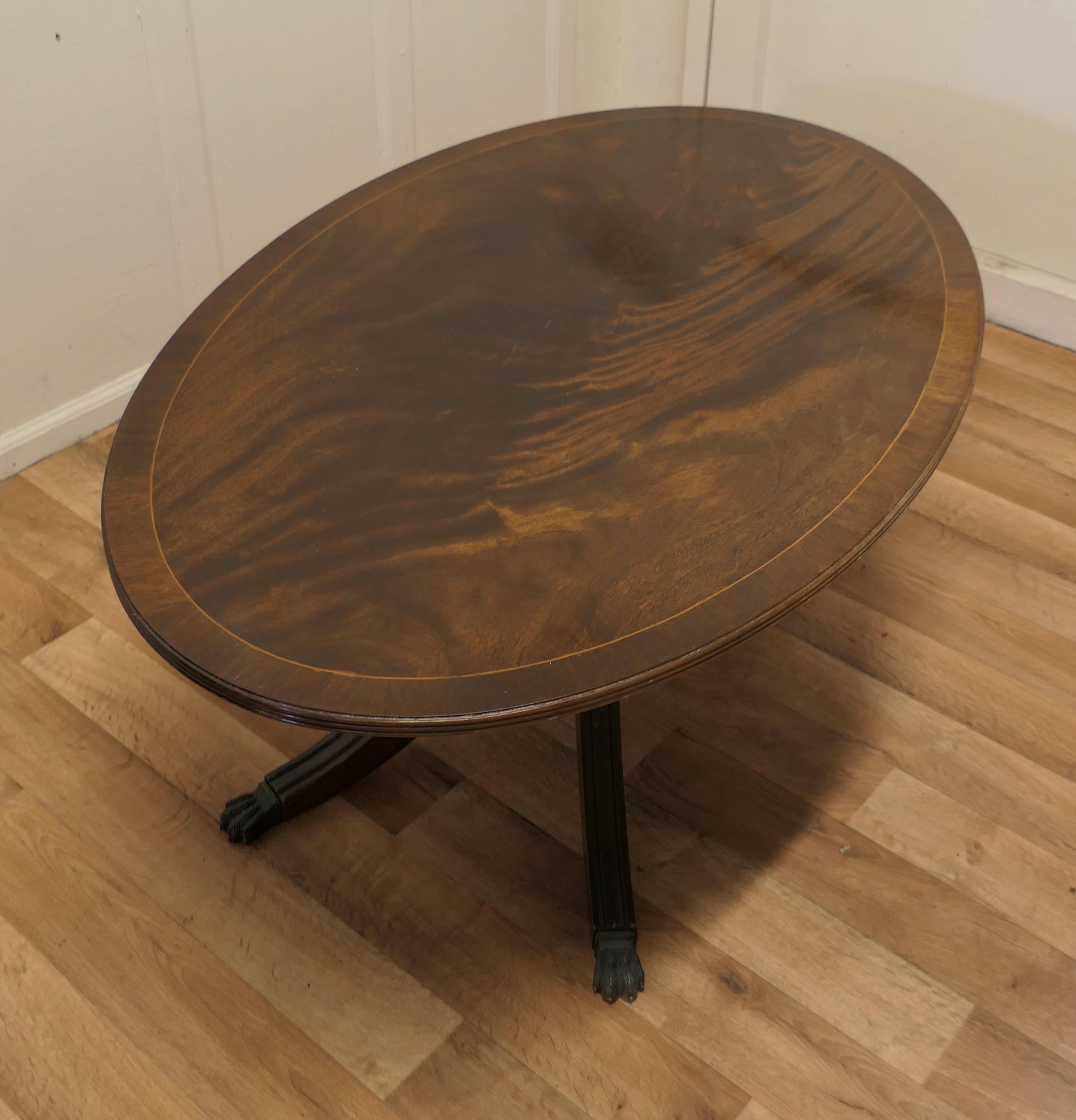 A large Regency Style flame mahogany coffee table

This is a very attractive piece, it is made in the style of an Oval regency dining table, with a decorative inlaid border
The table is good quality, it stands on a 4 footed leg and has a