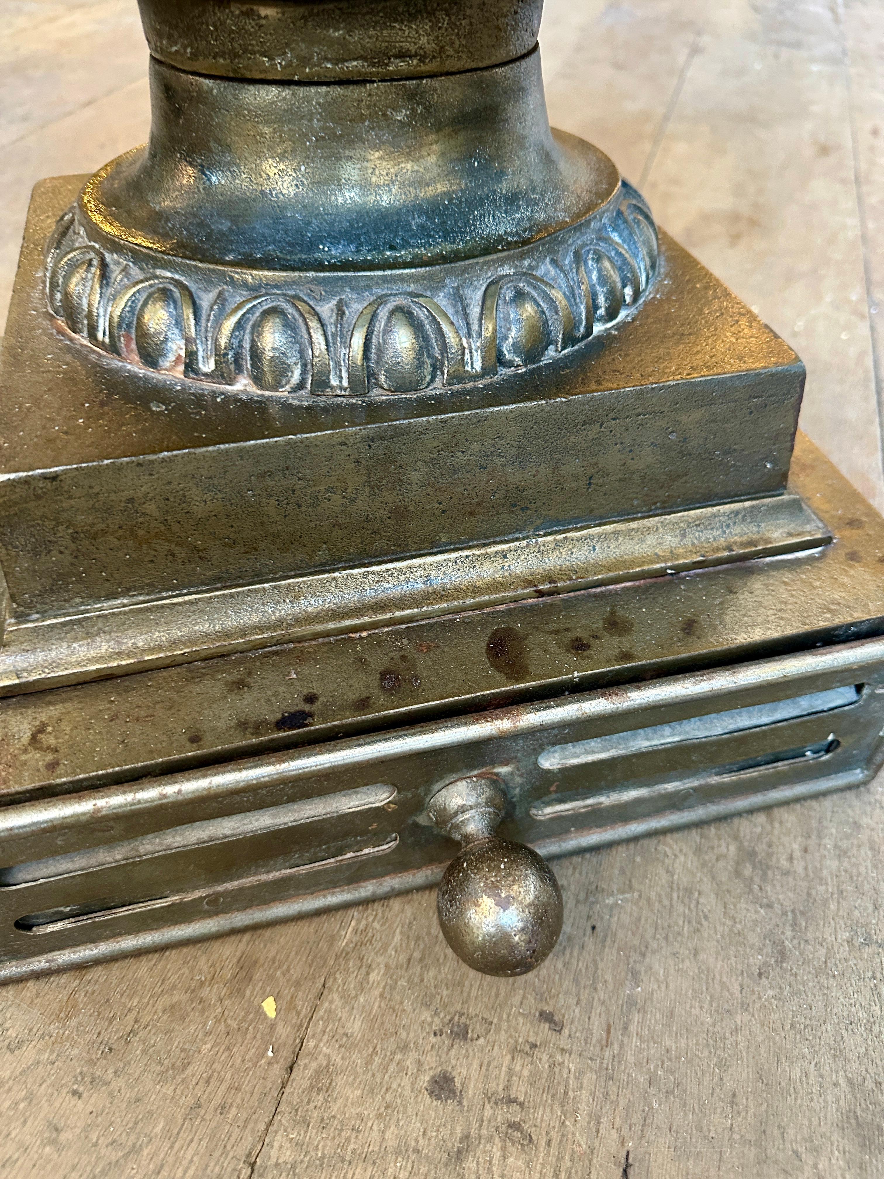 A very fine Urn grate in the Regency style. Finished in bronze patinated cast iron. Wrought Iron fire bars flanked by looped serpents. Decorated with swags, oval rosette and rams heads. The base with egg and dart socle, stod on a square plinth with