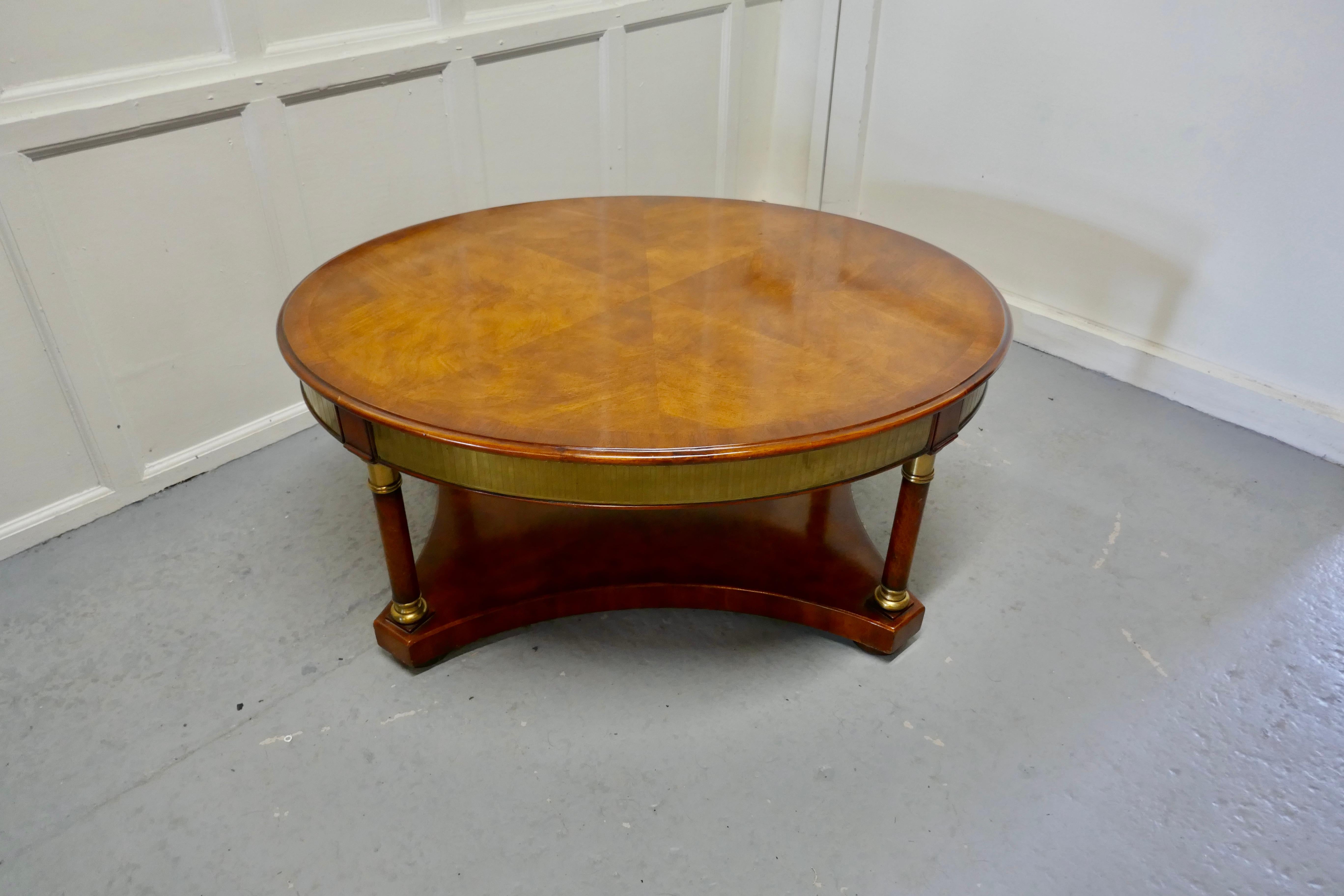 A large regency walnut and brass oval coffee table

This is a very attractive piece, it is made in the style of a regency games table, with applied brass decoration
The table is very fine quality and a very heavy piece, it stands on 4 column legs