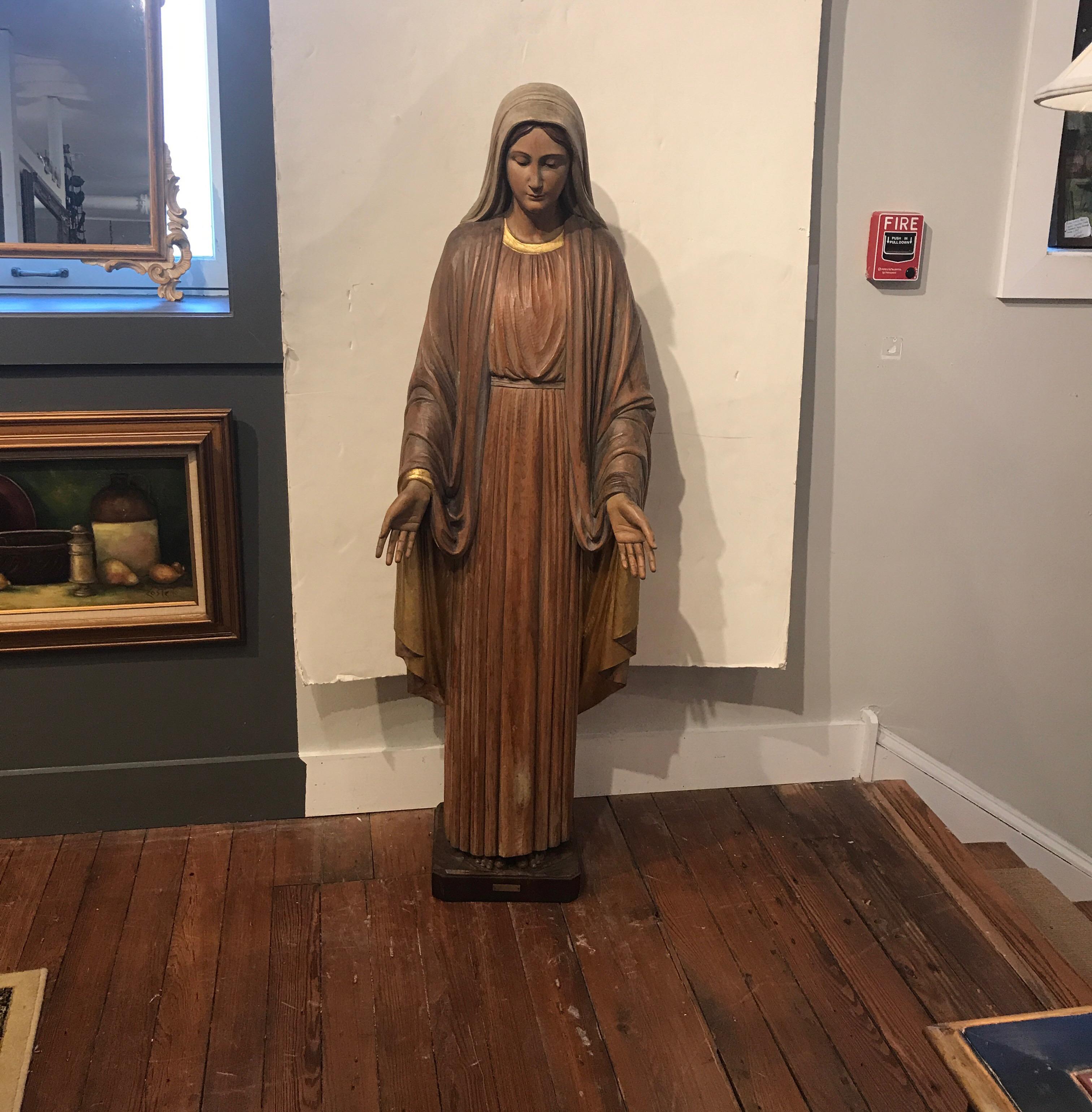 Beautiful hand carved wood sculpture of Mary. Near life and carved by a master carver with realistic face, beautiful draped robes and outstretched hands. The dressings with gilt highlights and original muted coloring to the entire sculpture. There