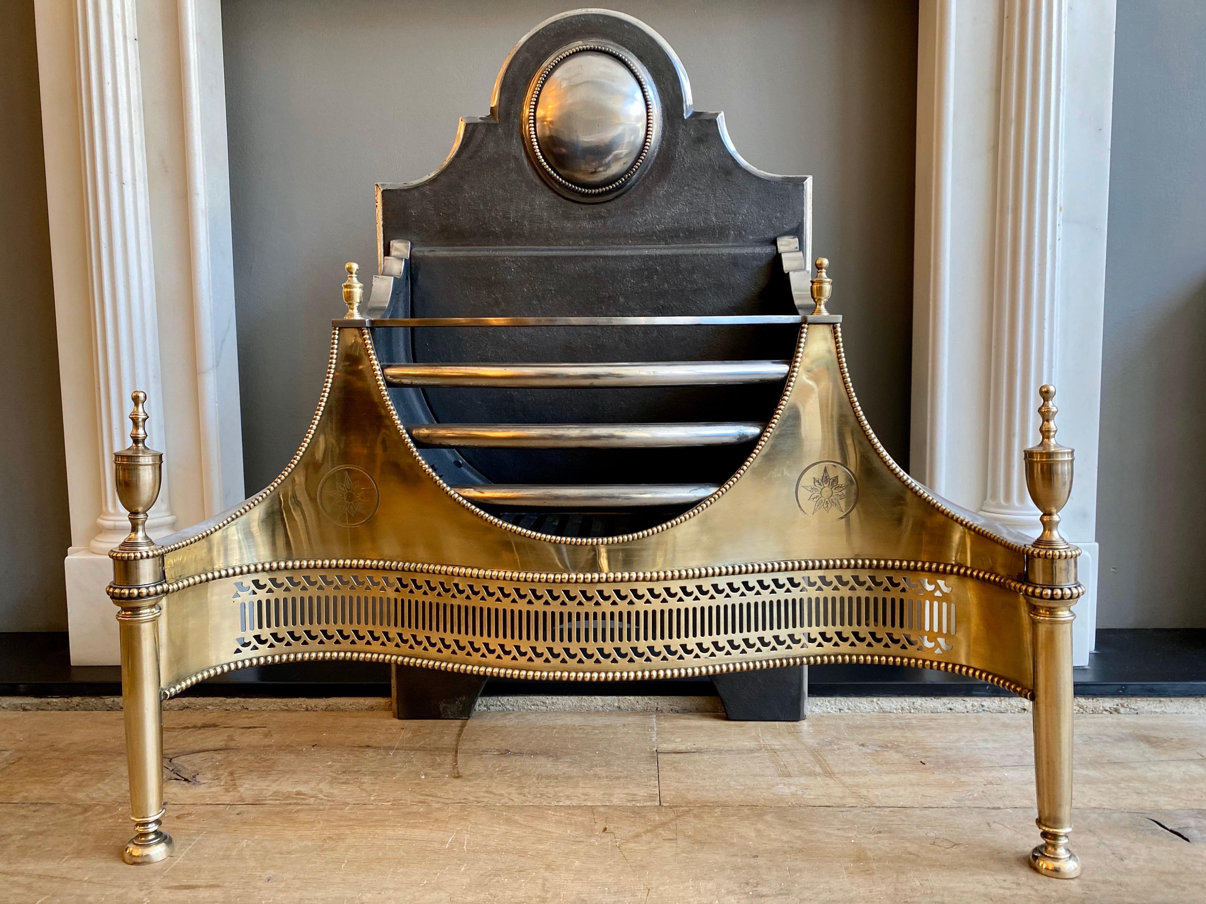 A good quality copy of an 18th century style Georgian fire grate. The pierced and beaded serpentine fretwork flanked by tapered rounded columns. The wide engraved wings also beaded framing bowed front burning bars. The shaped fireback with burnished