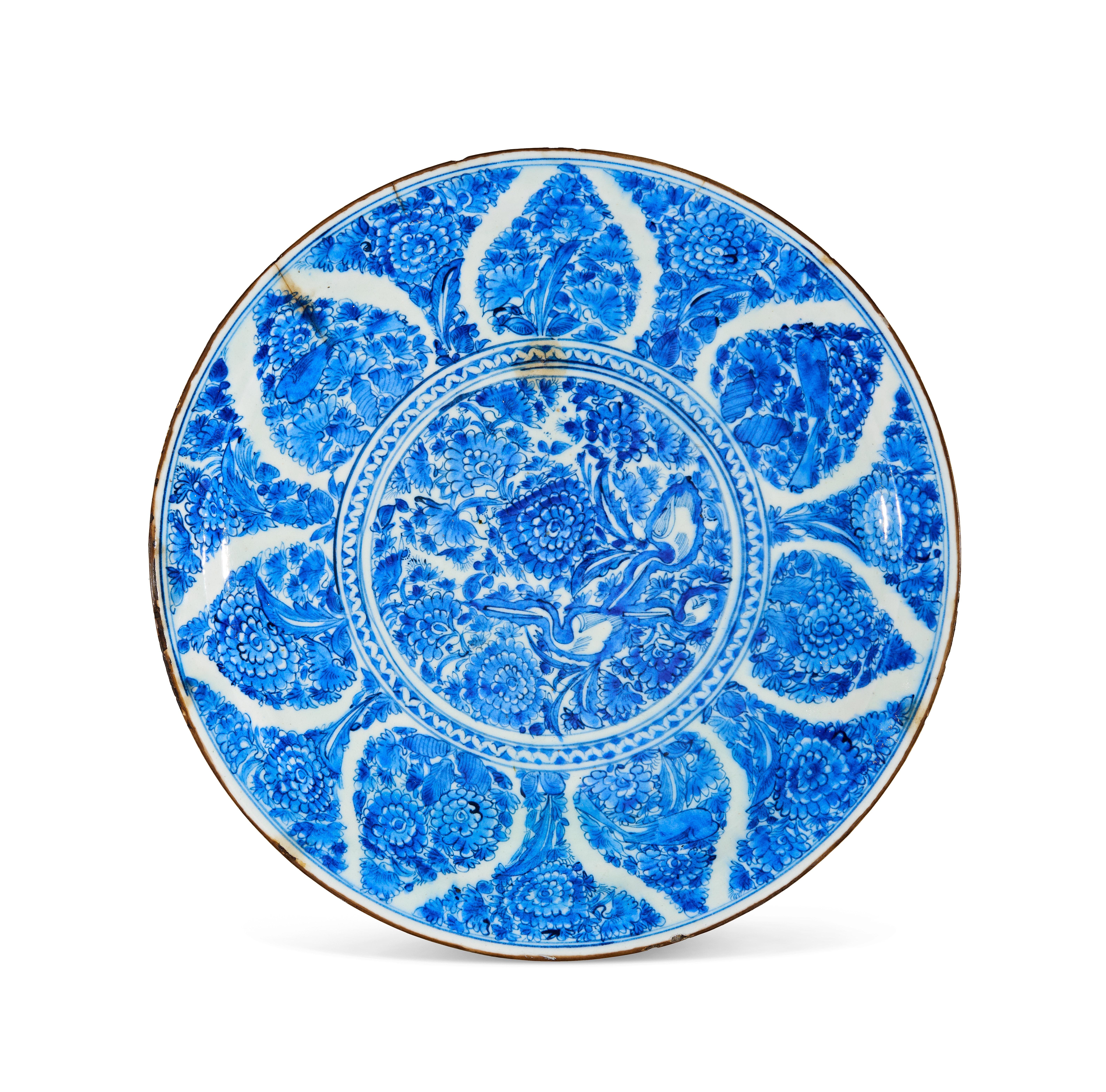 Large Safavid pottery dish painted in cobalt blue underglaze with a central medallion featuring birds among dense floral motifs. The cavetto is decorated with radiating petal-shaped panels filled with stylized flowers and foliage. The reverse is