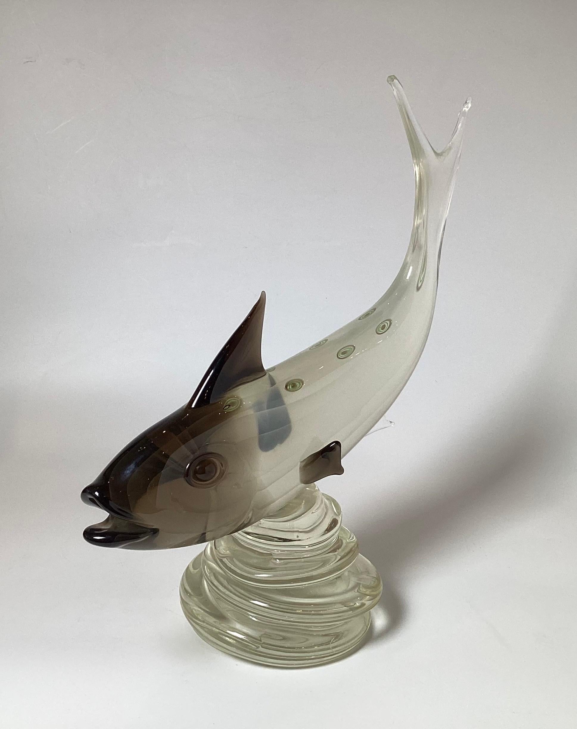 An impressive Italian Murano glass sculpture of a trout in hades of black, smoky grey  to clear glass.  The fish form with upward tail with black fins, with colorful bulls eye spots on the back, 20 inches tall, 18 inches wide, 8 inches deep 