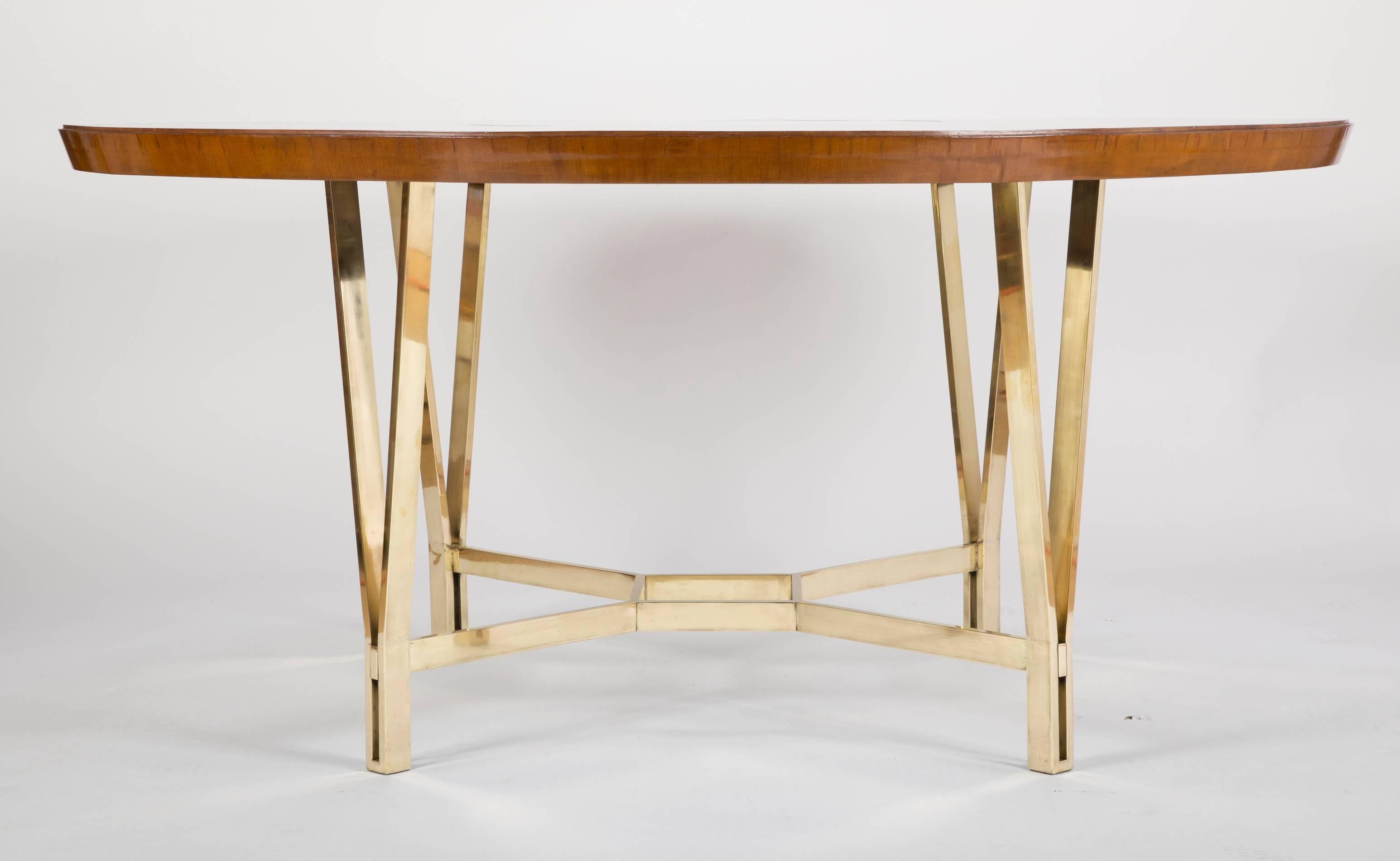 A Sapele wood center table with central glass filled cut-out. The large-scale table rests on a polished bronze base.