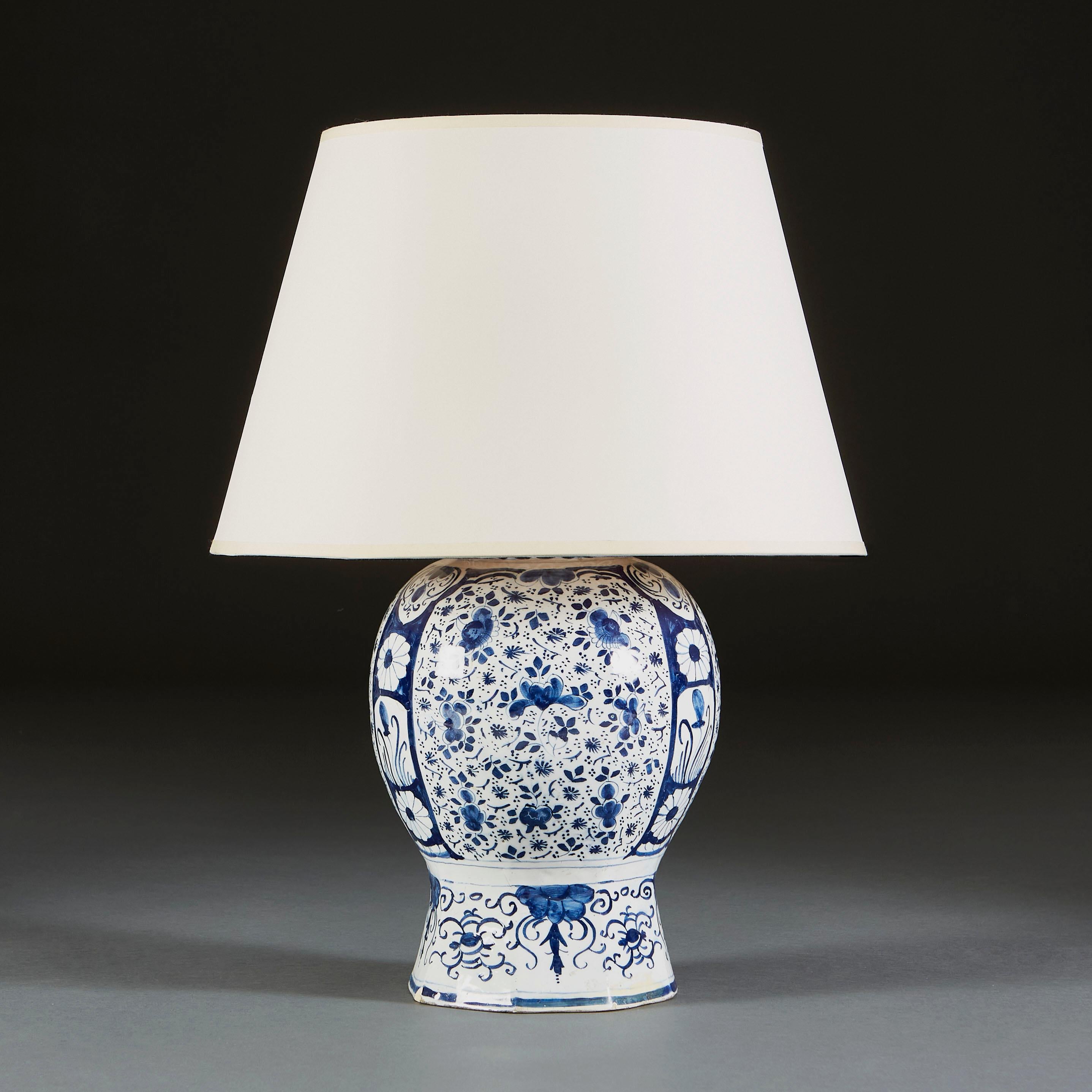 An eighteenth century blue and white delft vase, with delicate floral motifs bordered by larger bands of foliate designs, now as a lamp.

Currently wired for the UK. 

Please note: Lampshade not included.