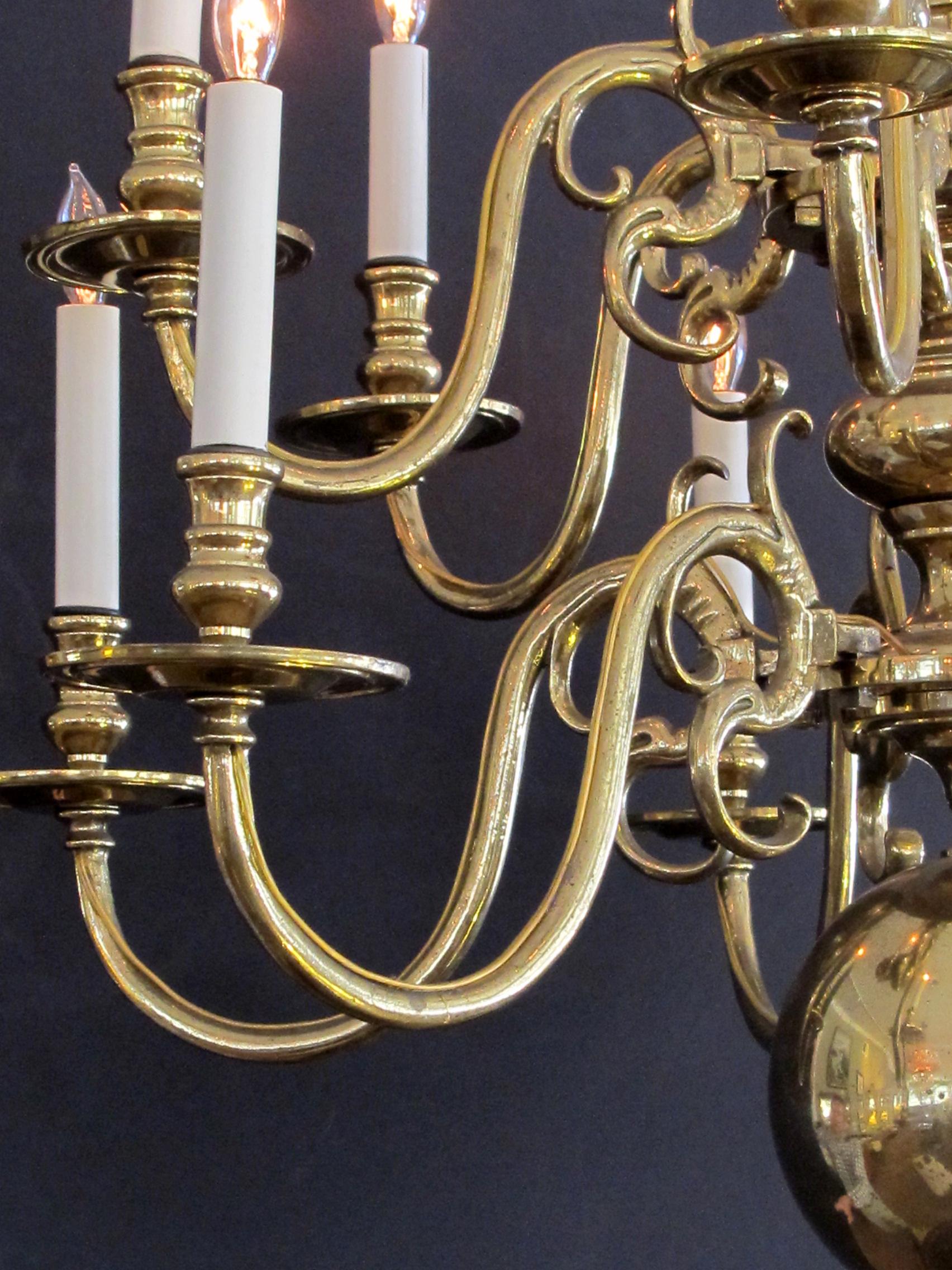 A large-scaled and good quality Dutch colonial style 2-tier 12-light chandelier; a large and well-proportioned chandelier with solid brass scrolled arms emanating from a baluster-shaped column terminating in a large sphere; new French wiring.