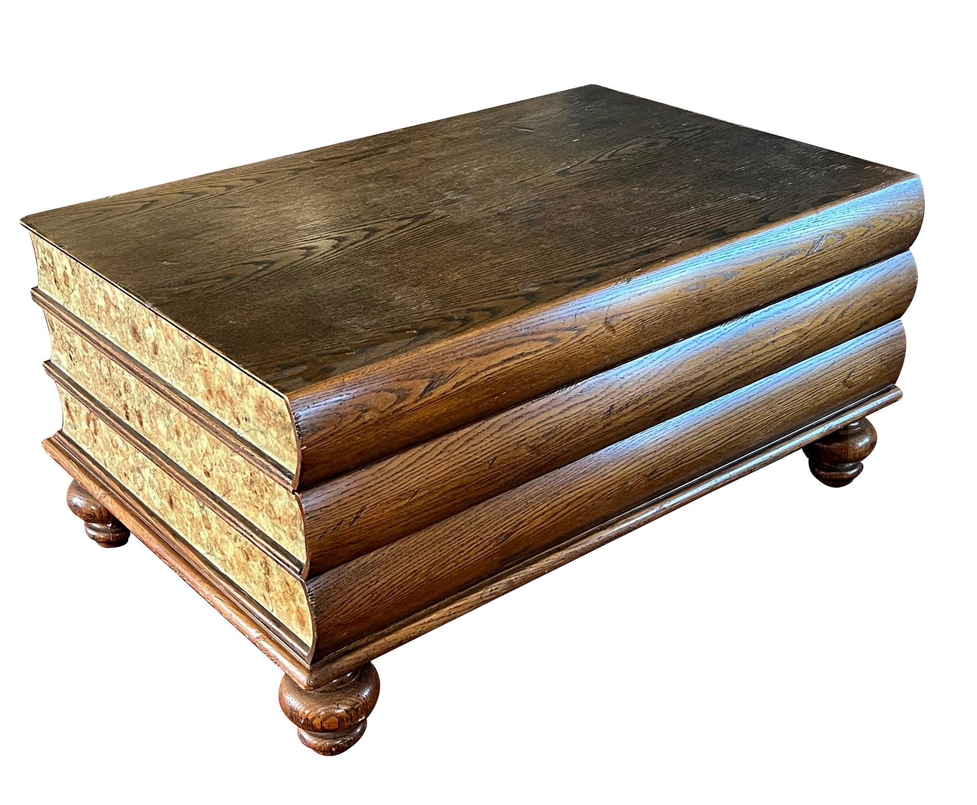 the curious coffee table depicting three over-scaled books with oak covers and spines and faux marble painted 'paper'; all raised on short bulbous turned supports; the single drawer interior with maker's label 'Roundtree Country Reproductions'