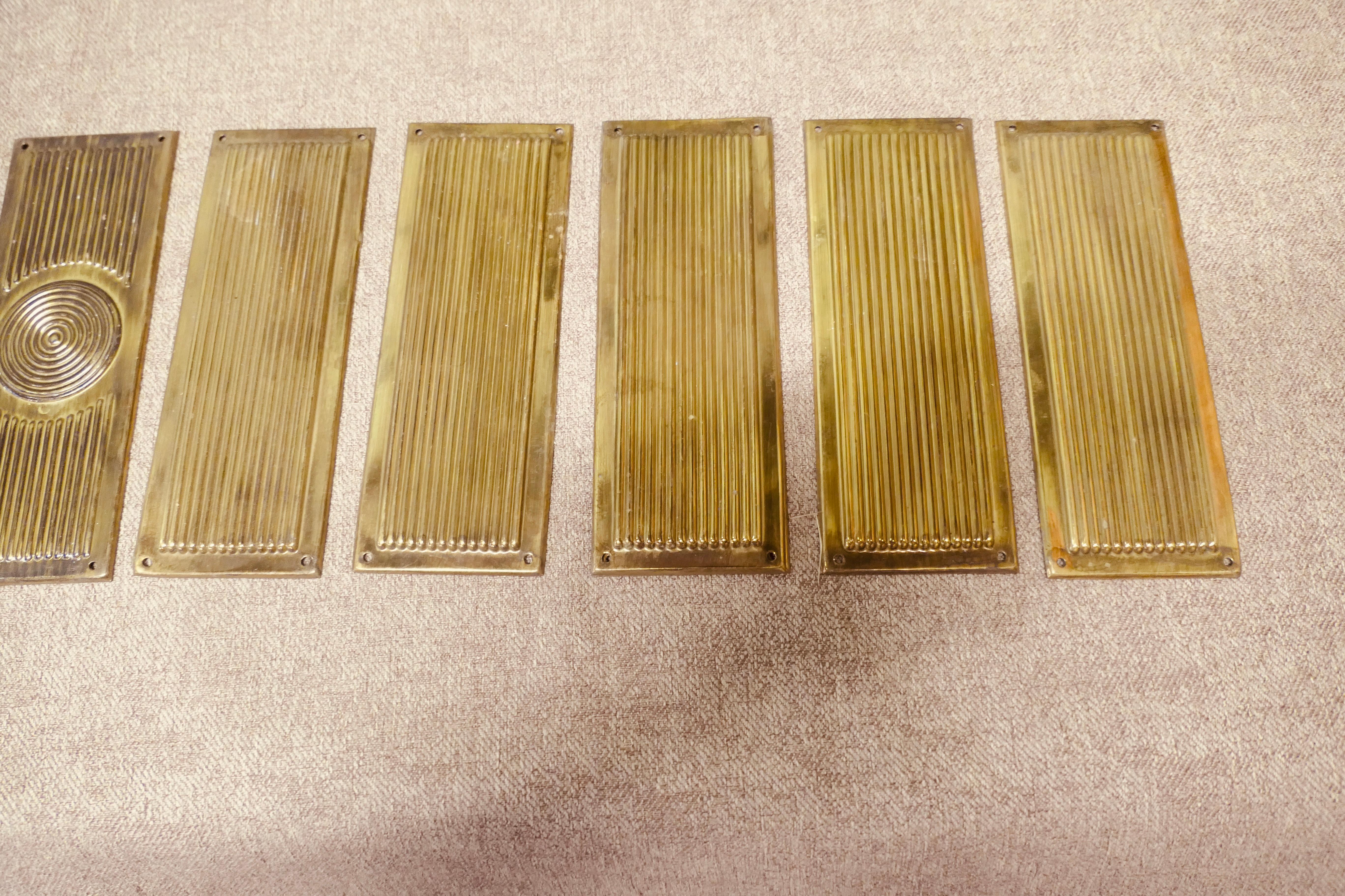 A Large Set of 12 Art Deco Brass Door Finger Plates 

There are 12 brass plates in the set, they are made in pressed brass and 3 have a swirl pattern, the 9 are reeded
The plates are in good used condition and they have small screw fixing holes,