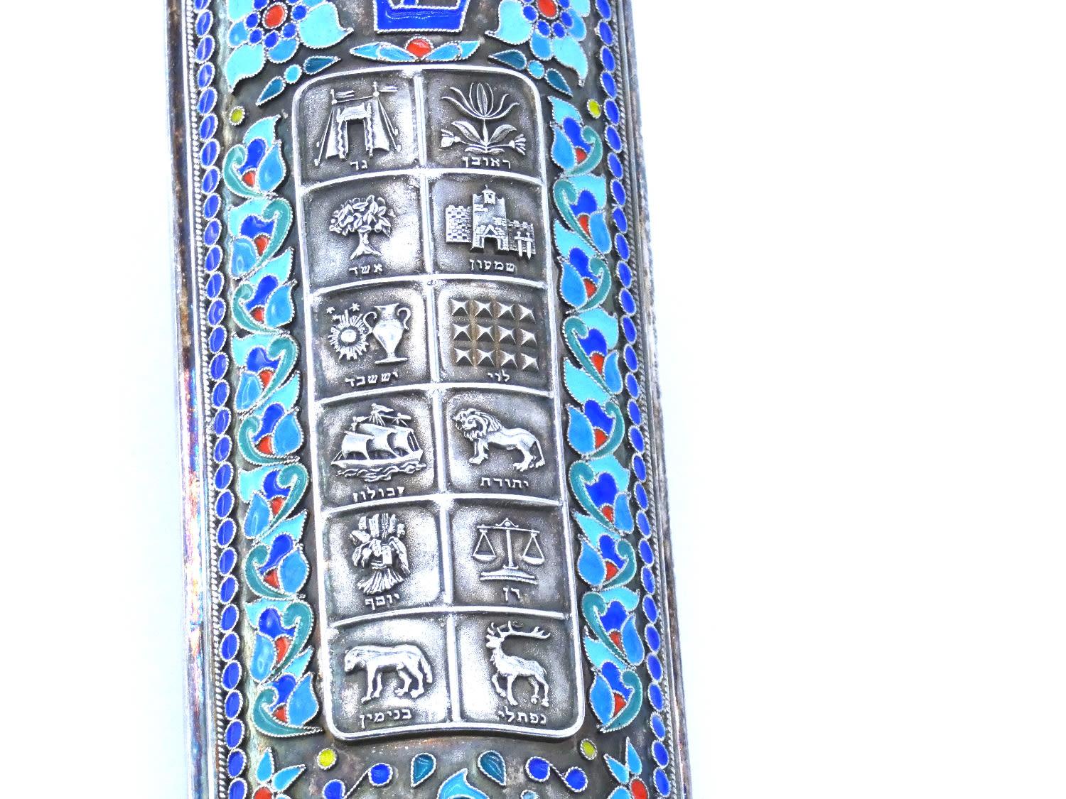 A Large Silver Enamel Mezuzah Case, Henryk Winograd, New York 1996

Decorated with beautiful blue anemones in enamel surrounded by blue pearl-beaded design in enamel. Centered by a rectangular plaque with names and symbols of each of the twelve