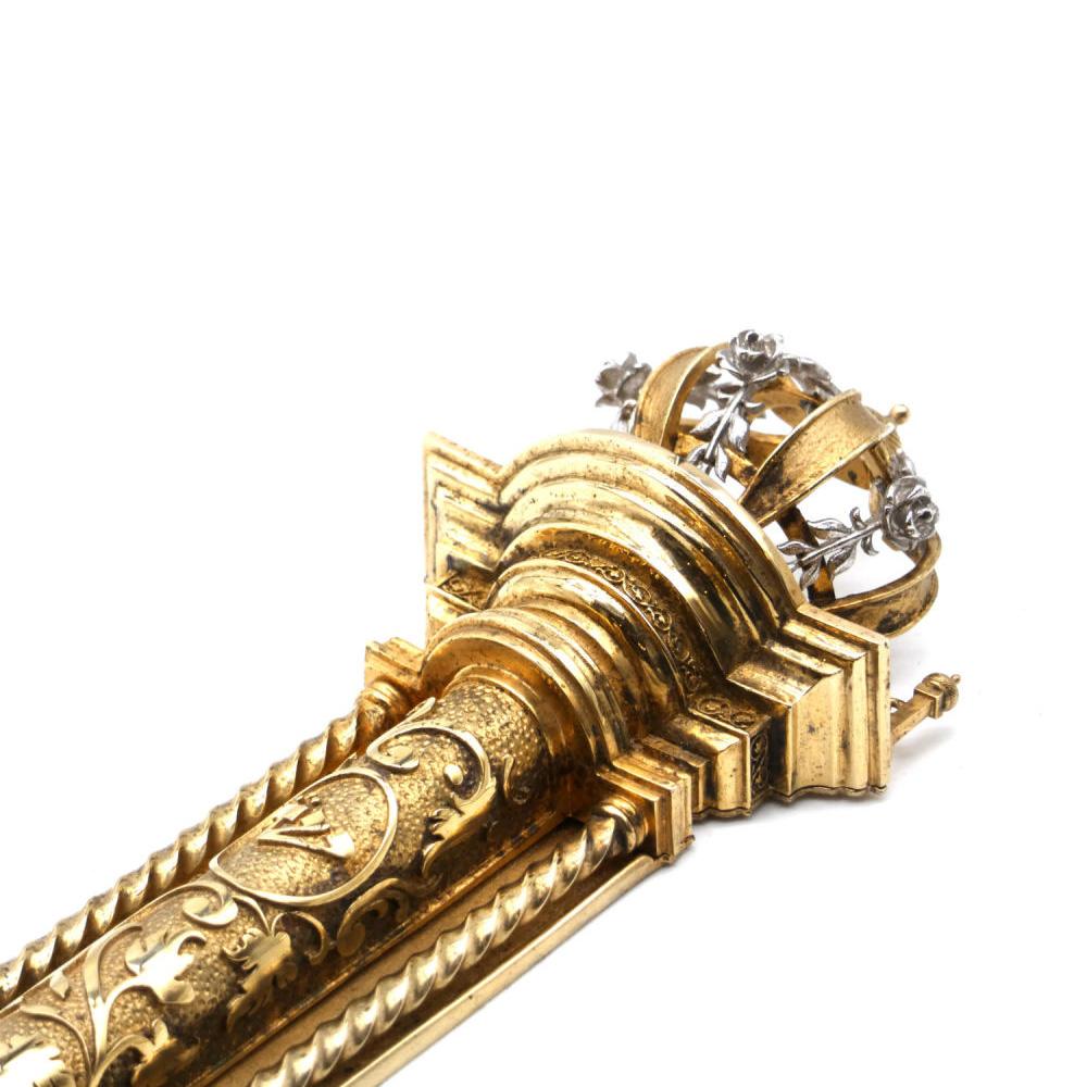 Magnífica caja de Mezuzah dorada con forma de columna dórica romana decorativa sólo que más impresionante. En la base inferior de la columna hay dos pequeñas columnas con una cadena unida y una gran semicúpula semiesférica sobre una plataforma,