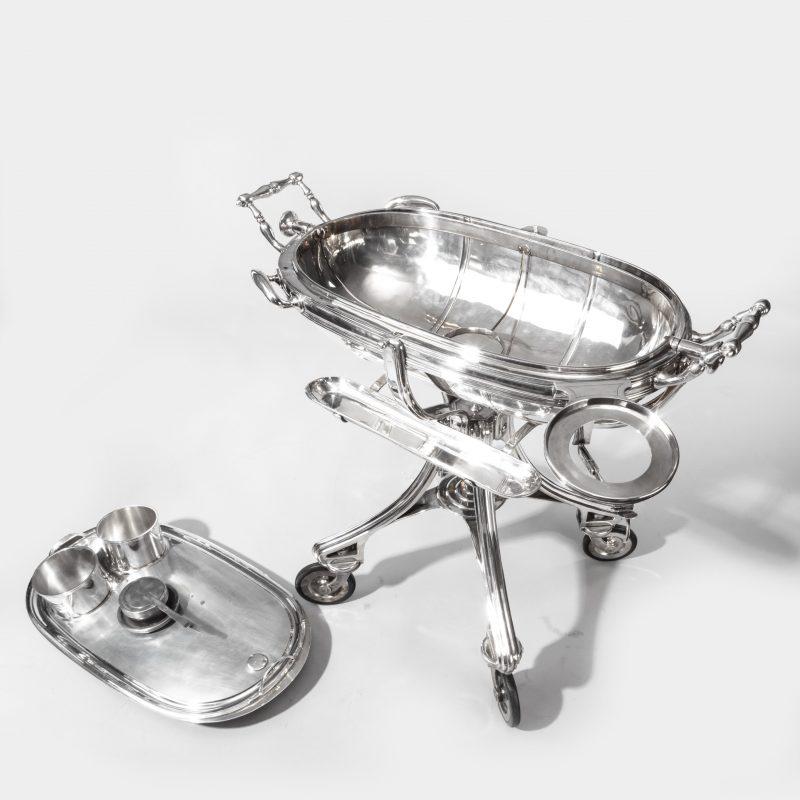 A large silver plate carving trolley or roast beef trolley by Erguis, the domed, hinged lid opening to reveal the water-heated carving plate set with two compartments for gravy, also with an interior shelf for carving knives and other utensils, all