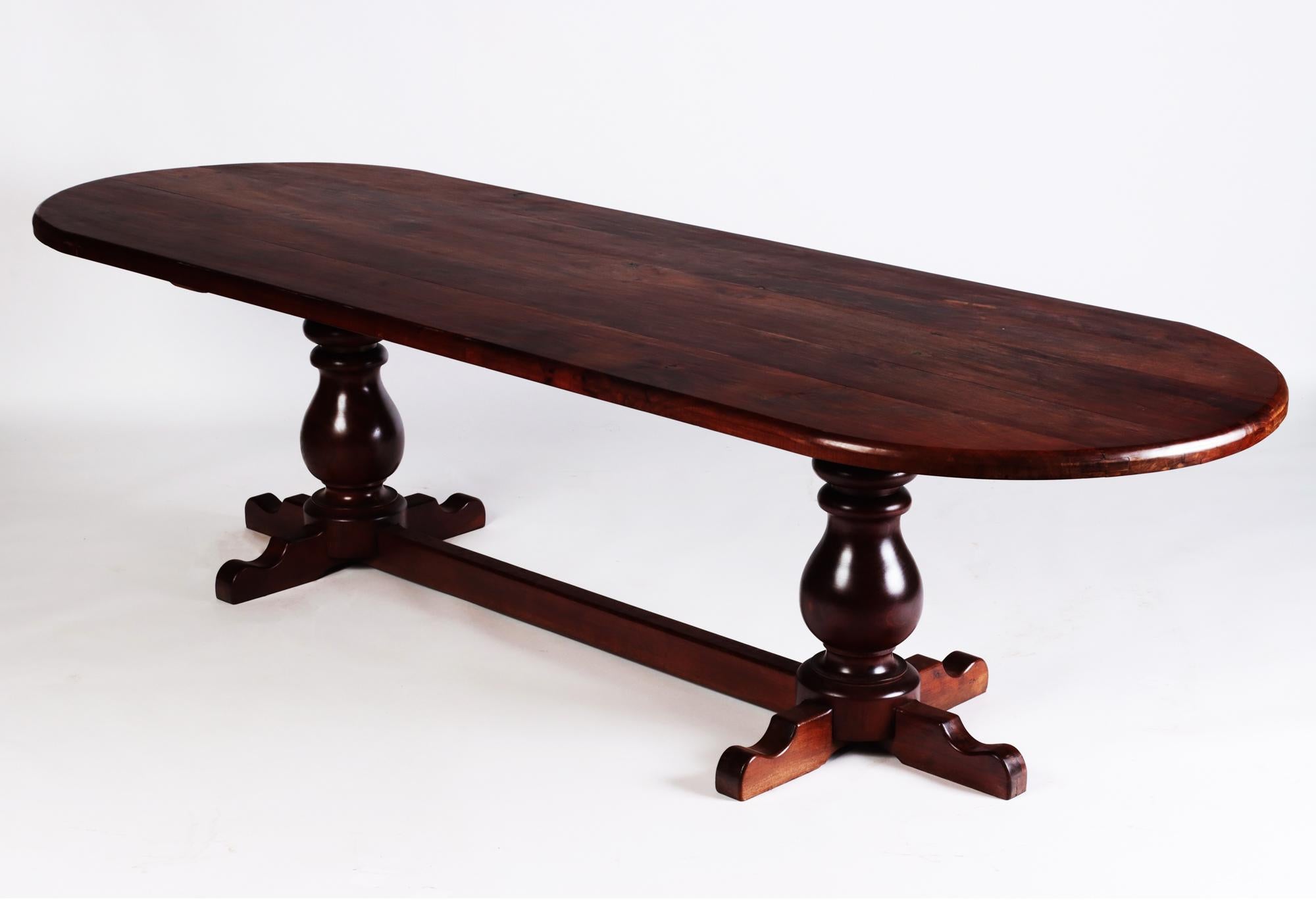 A large slab top oval shape Brazilian trestle table circa 1960. The two turned legs are joined with a cross stretcher.