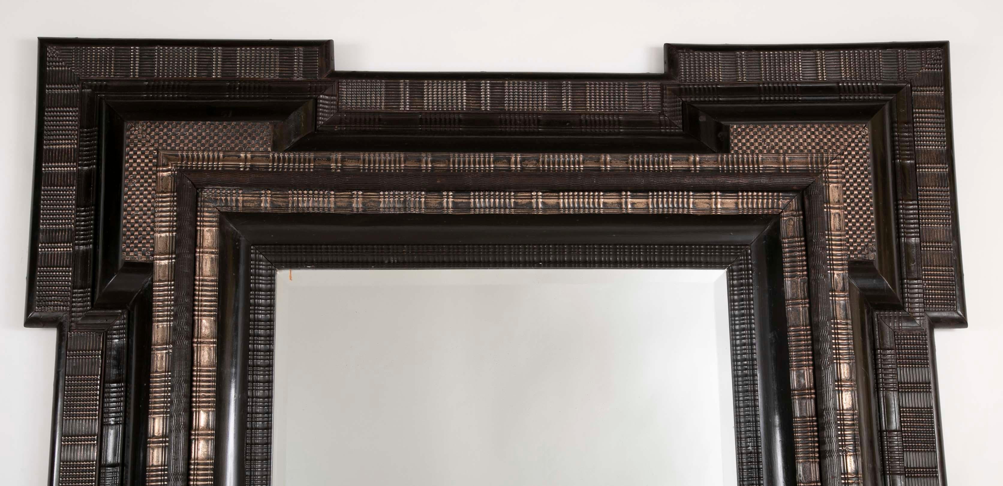 A monumental Dutch frame with repousse silvered metal mounts and beveled glass mirror, circa mid-19th century.